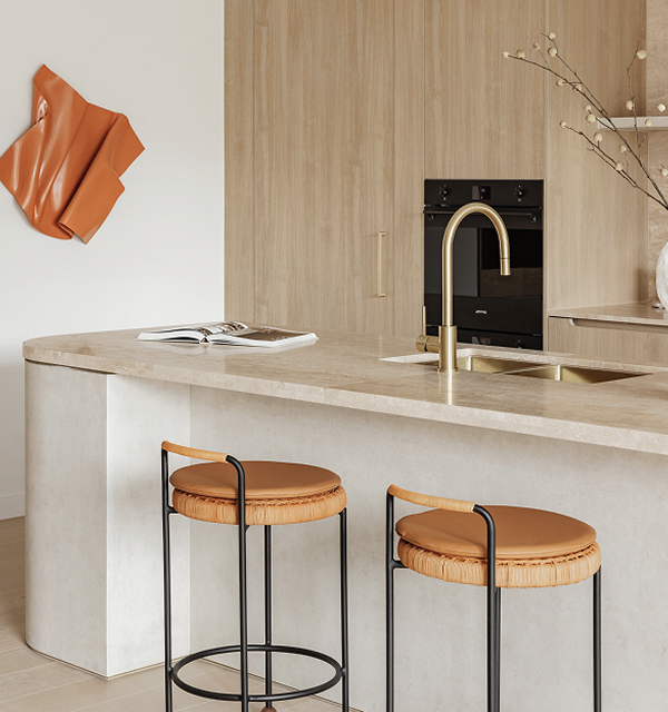 Modern kitchen with marble island, brass faucet, two brown cushioned stools, and wood cabinetry.