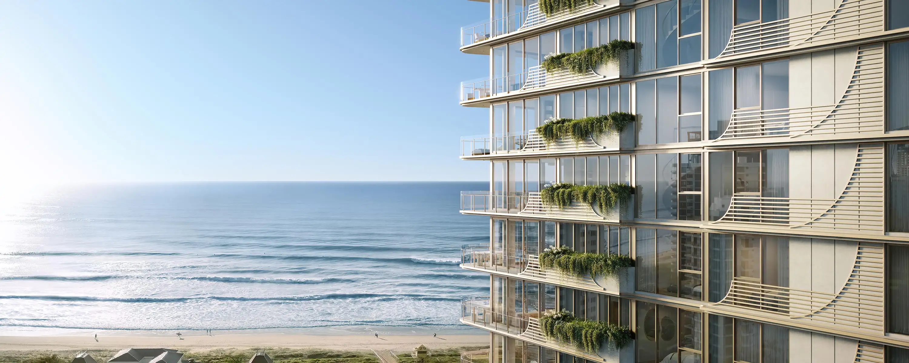 Modern building with curved balconies and greenery overlooking a beach and calm ocean waves.