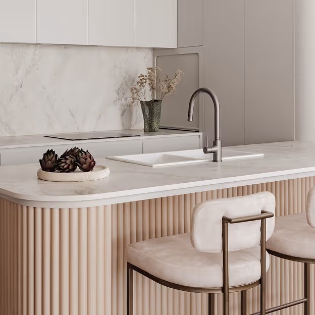 Modern bathroom countertop with two white vessel sinks, brass faucet, mirror, and decorative plant.