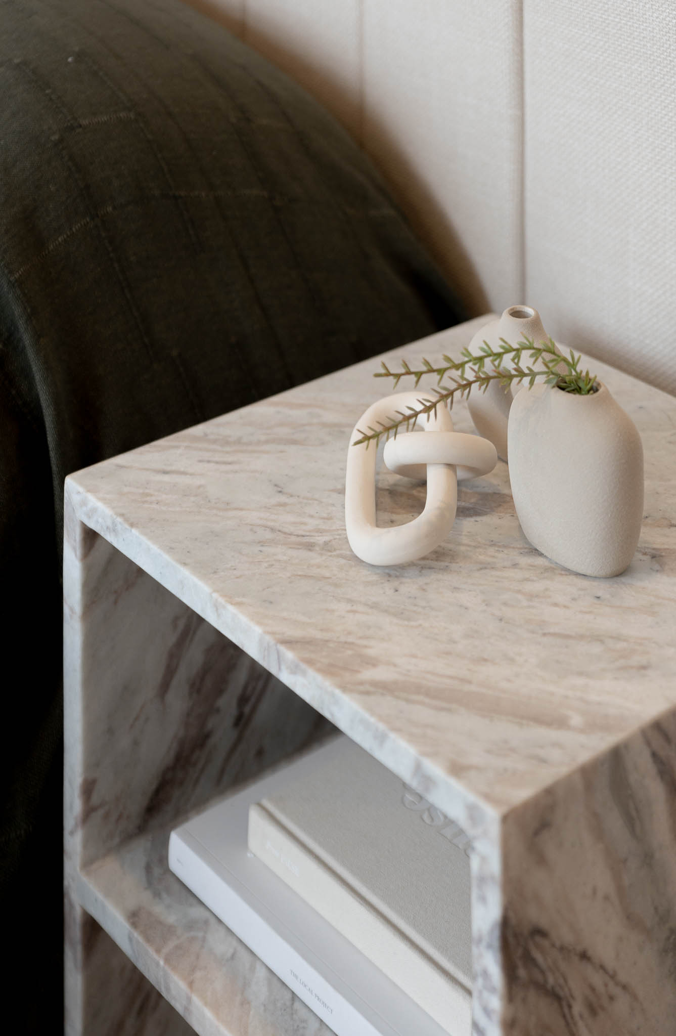 Modern bathroom counter with two round sinks, brass faucet, mirror, and decorative plant.