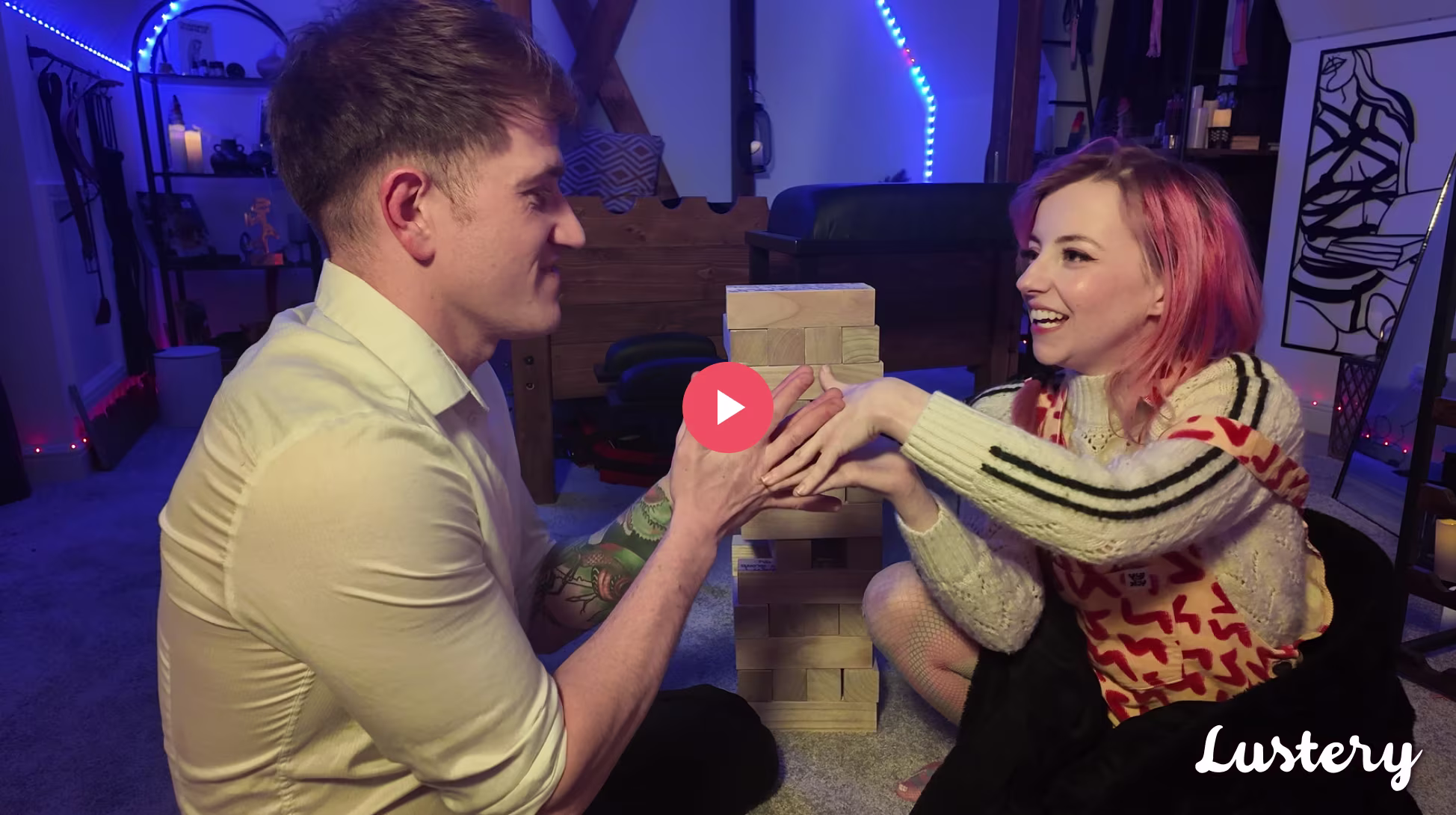 Alice Lovegood and Mister Lovegood smiling in their blue lit bedroom playing Jenga
