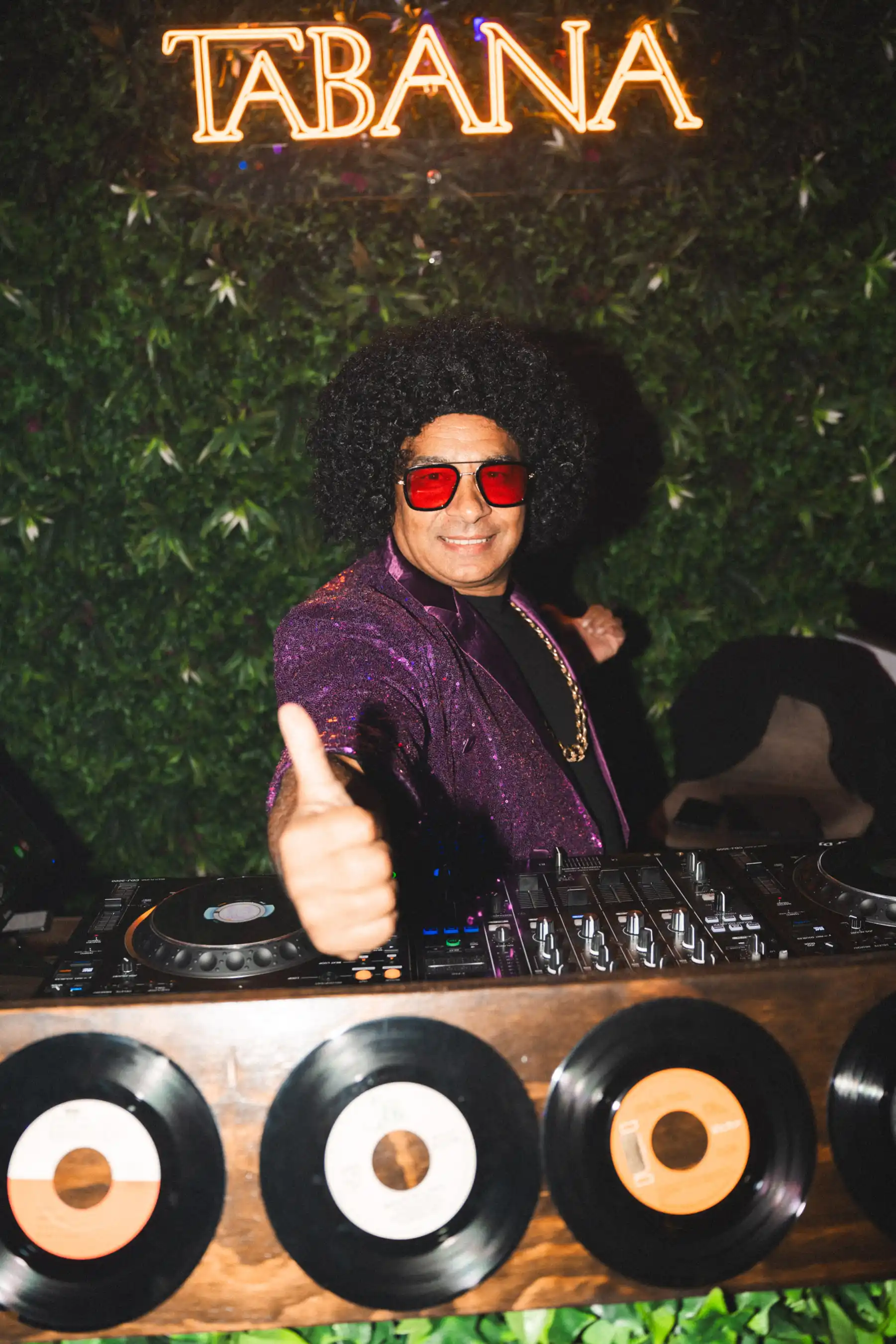 DJ performing at Tabana Night Fever with Tabana logo backdrop