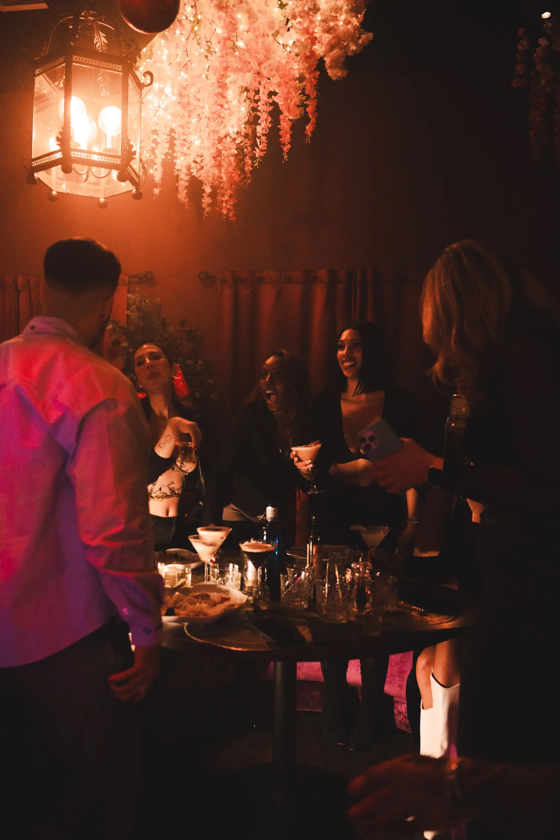 Group of guests enjoying cocktails and celebrations inside Tabana at the Dirty Santa event.