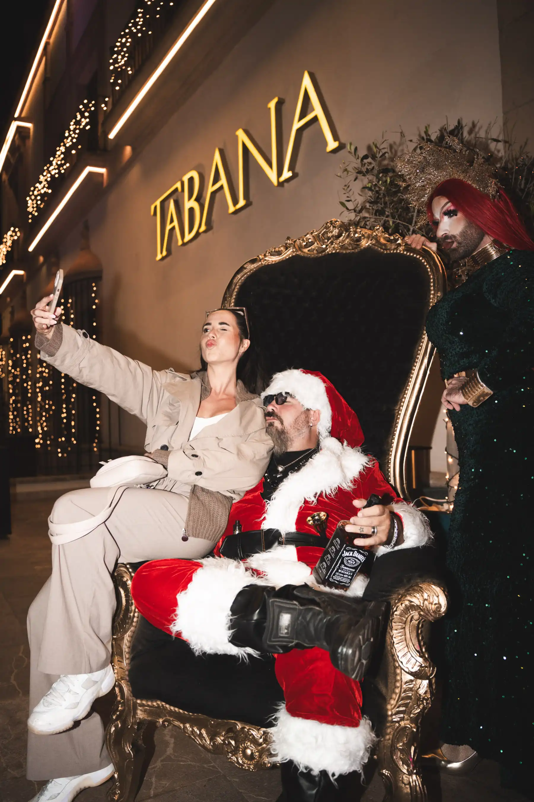 anta Claus posing outside Tabana with guests taking selfies during the Dirty Santa event.