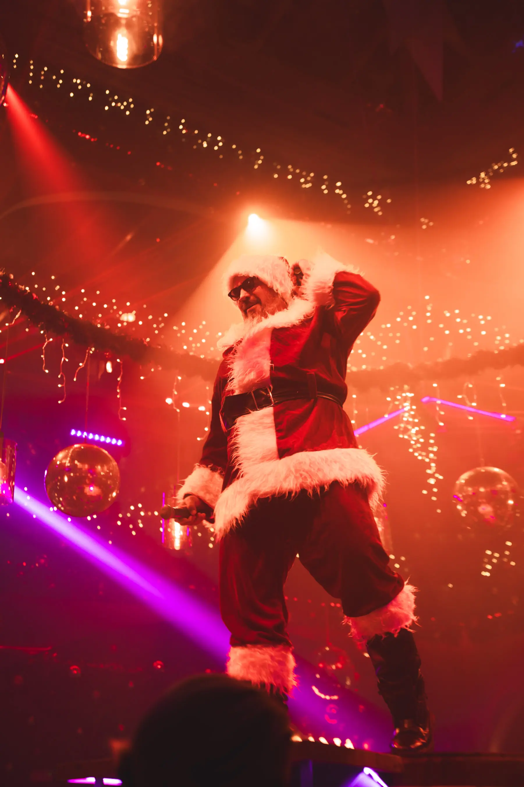 Santa Claus performing on stage with dancers at Tabana’s Dirty Santa holiday show.