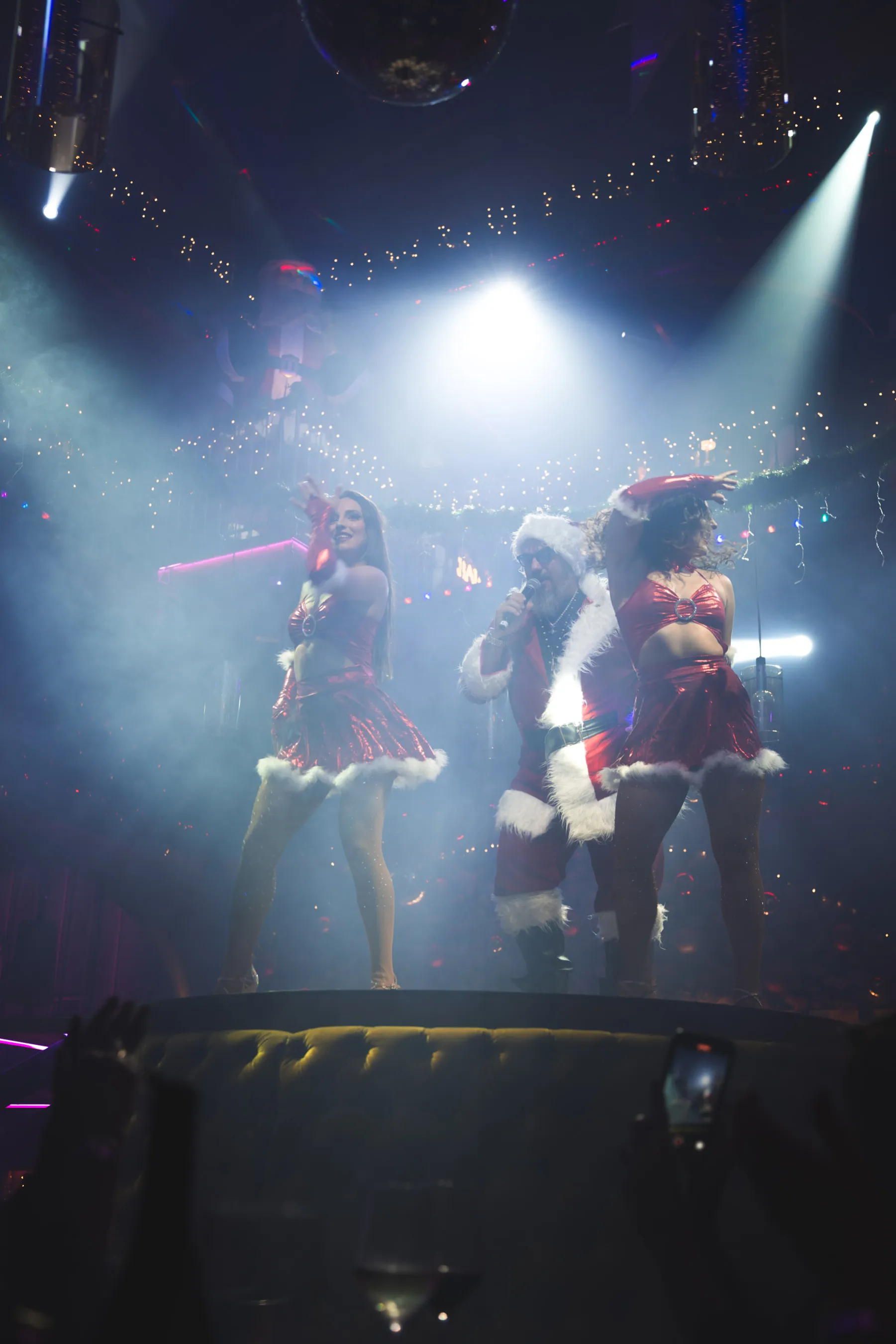 Santa Claus performing on stage with dancers at Tabana’s Dirty Santa holiday show.