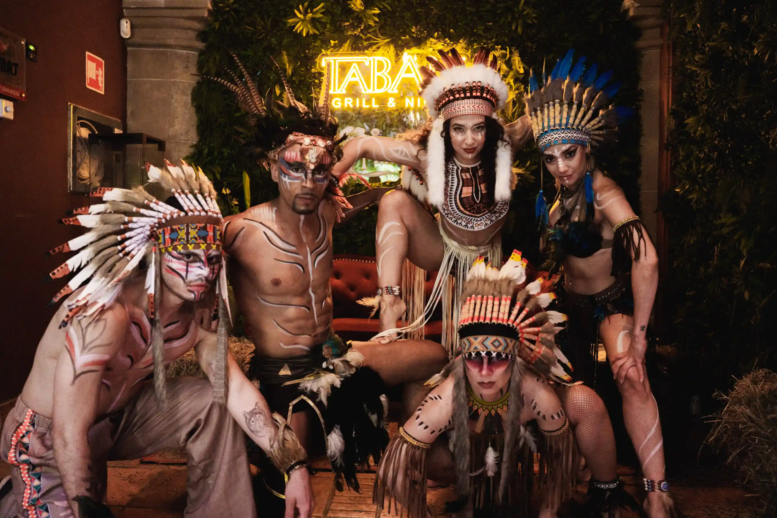 Rodeo show performers – Dancers in tribal-inspired costumes with feathered headdresses, delivering a dramatic live performance for the crowd.