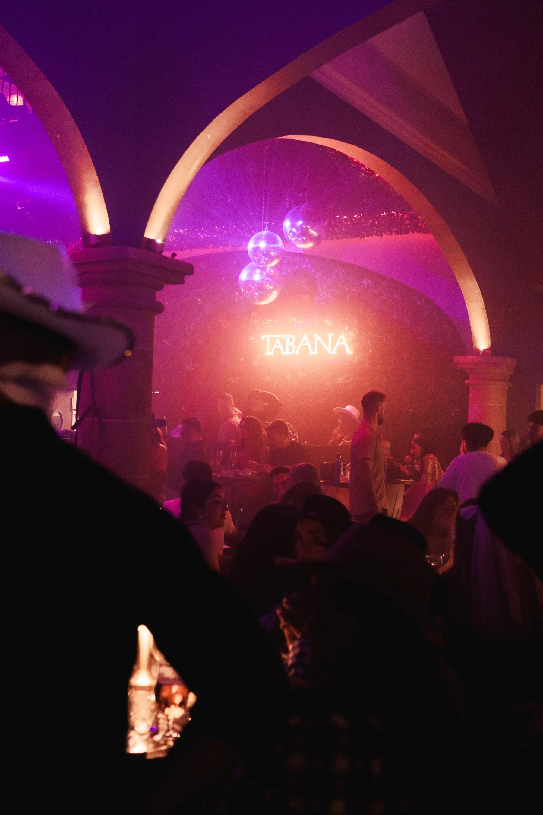 Atmospheric nightlife scene – Guests enjoying cocktails and music under glowing lights and disco balls at the Rodeo Event.