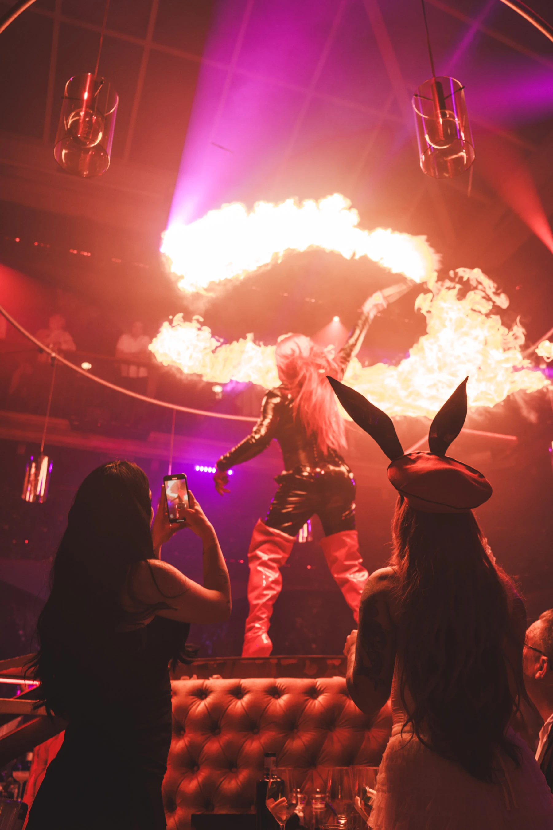 Performer in bunny outfit spinning fire on stage during Bunny Mansion show.