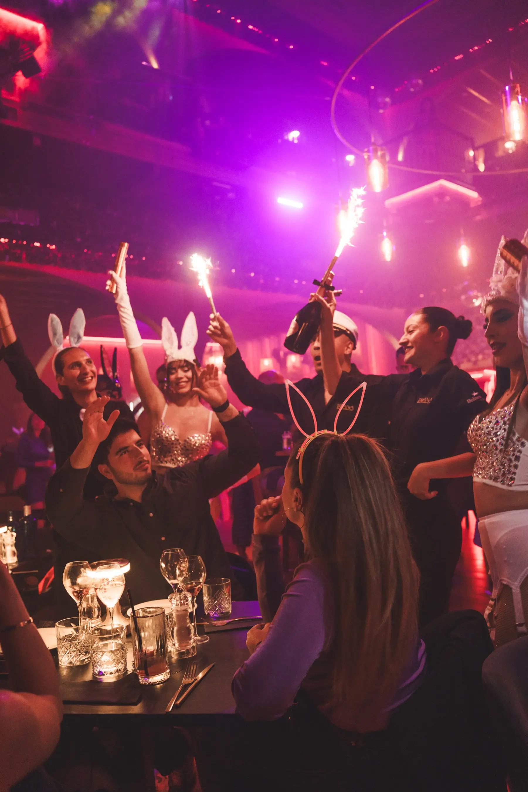 Guests in bunny costumes seated at tables enjoying dinner and drinks.