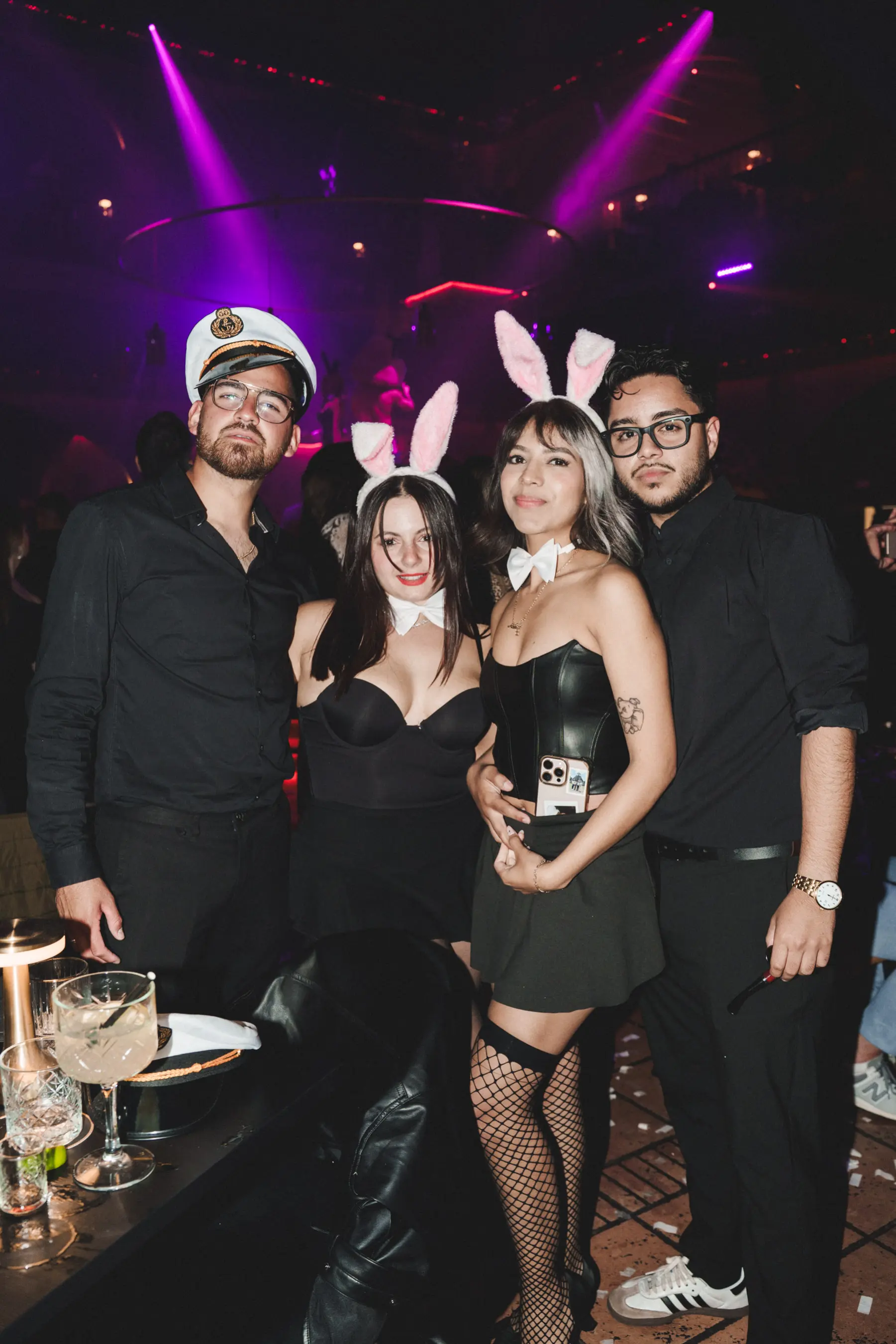Group of guests in bunny and captain costumes posing together at Tabana nightclub.
