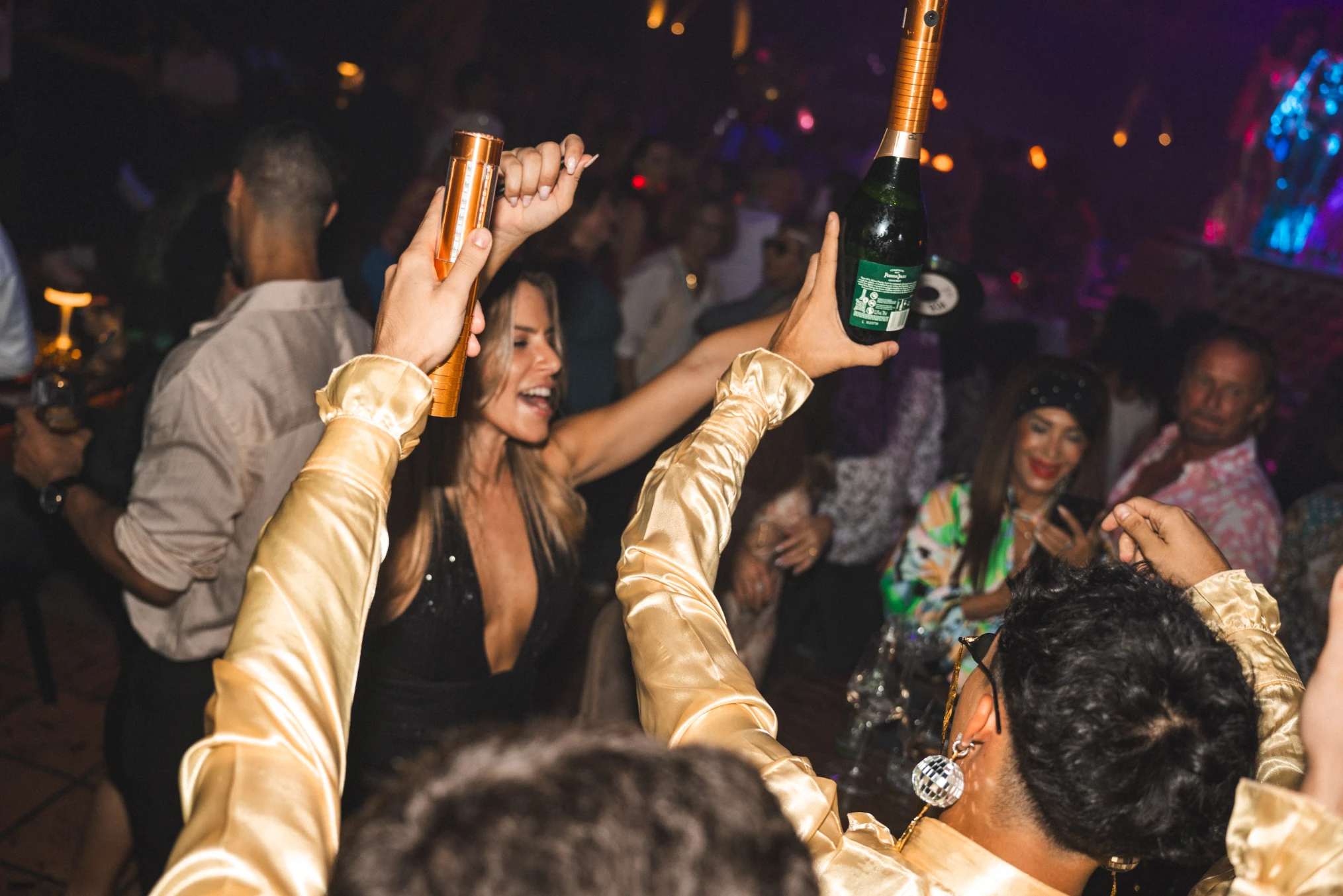 A festive group at a Tabana, toasting with champagne bottles, capturing the vibrant nightlife of Playa de Palma.