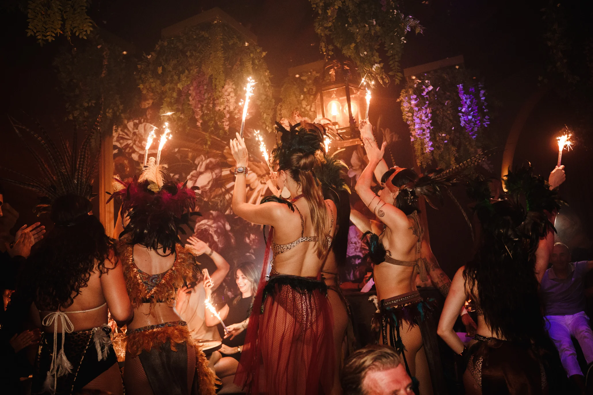 A dynamic scene of women in costumes dancing with torches, showcasing the vibrant nightlife in Playa de Palma.