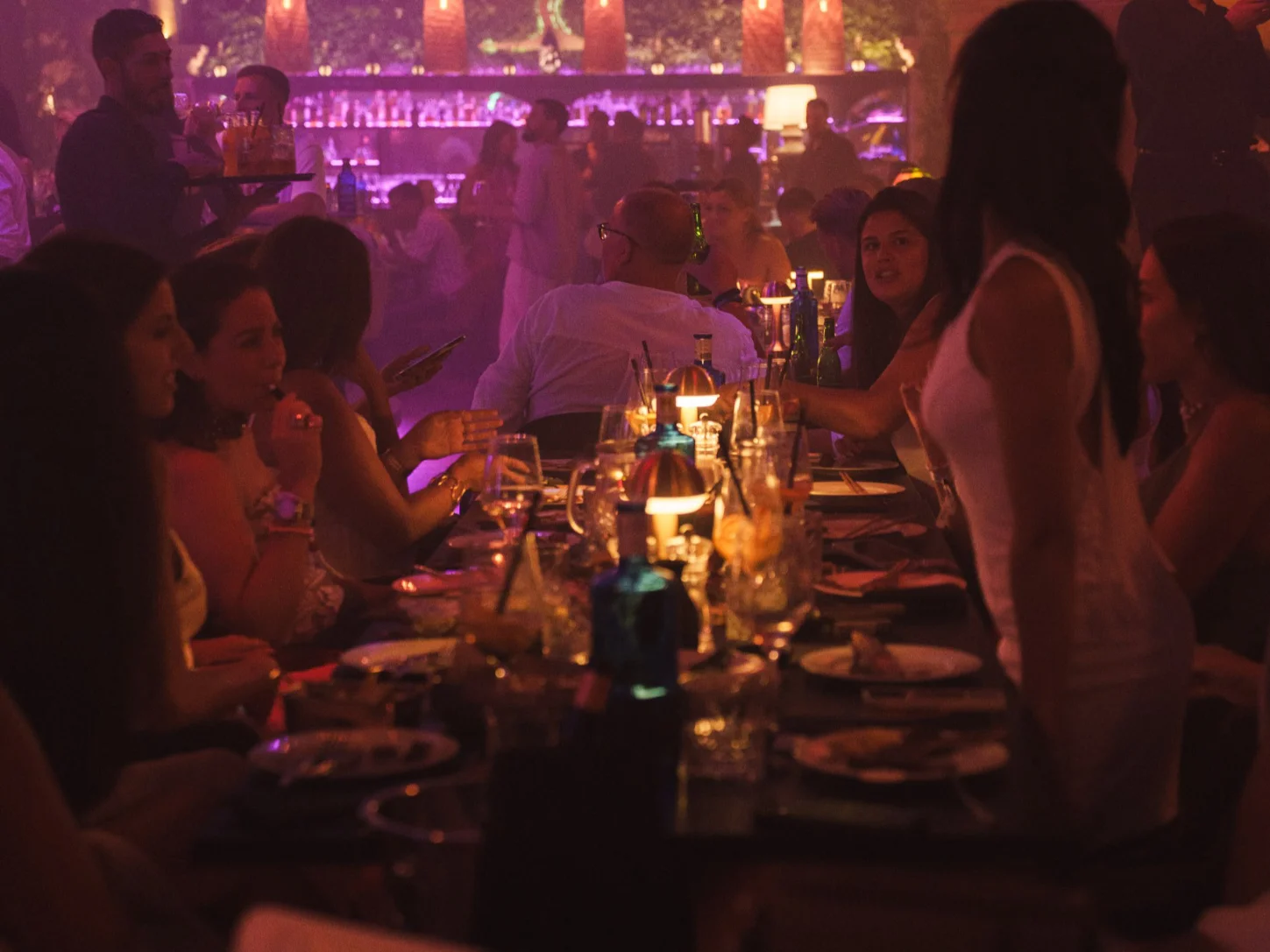 Un grupo animado disfruta de una cena en una mesa en Tabana, un restaurante de moda en Mallorca, durante una cena con espectáculo.