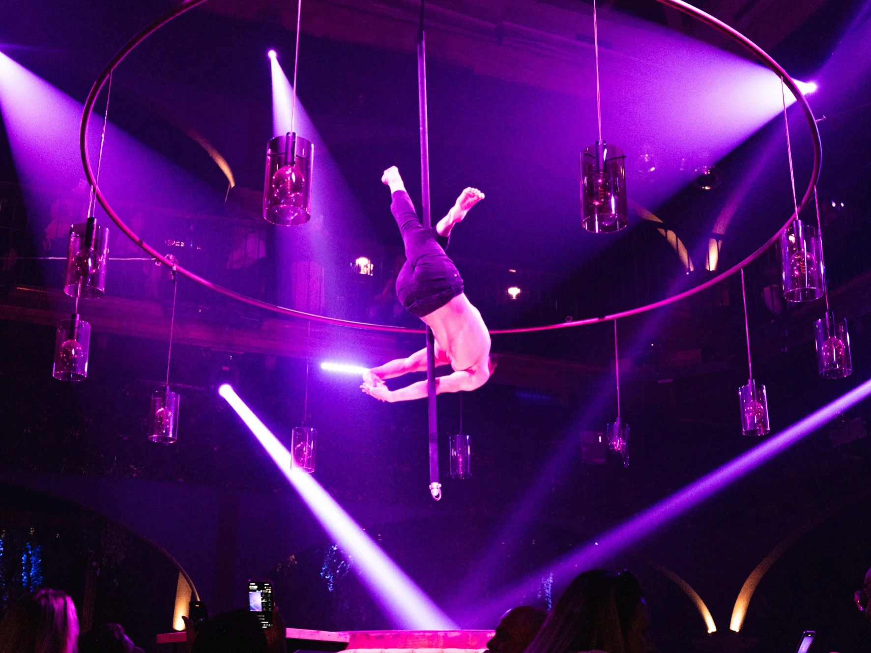 Aerial acrobat performing above guests during a live dinner show at Tabana in Mallorca.