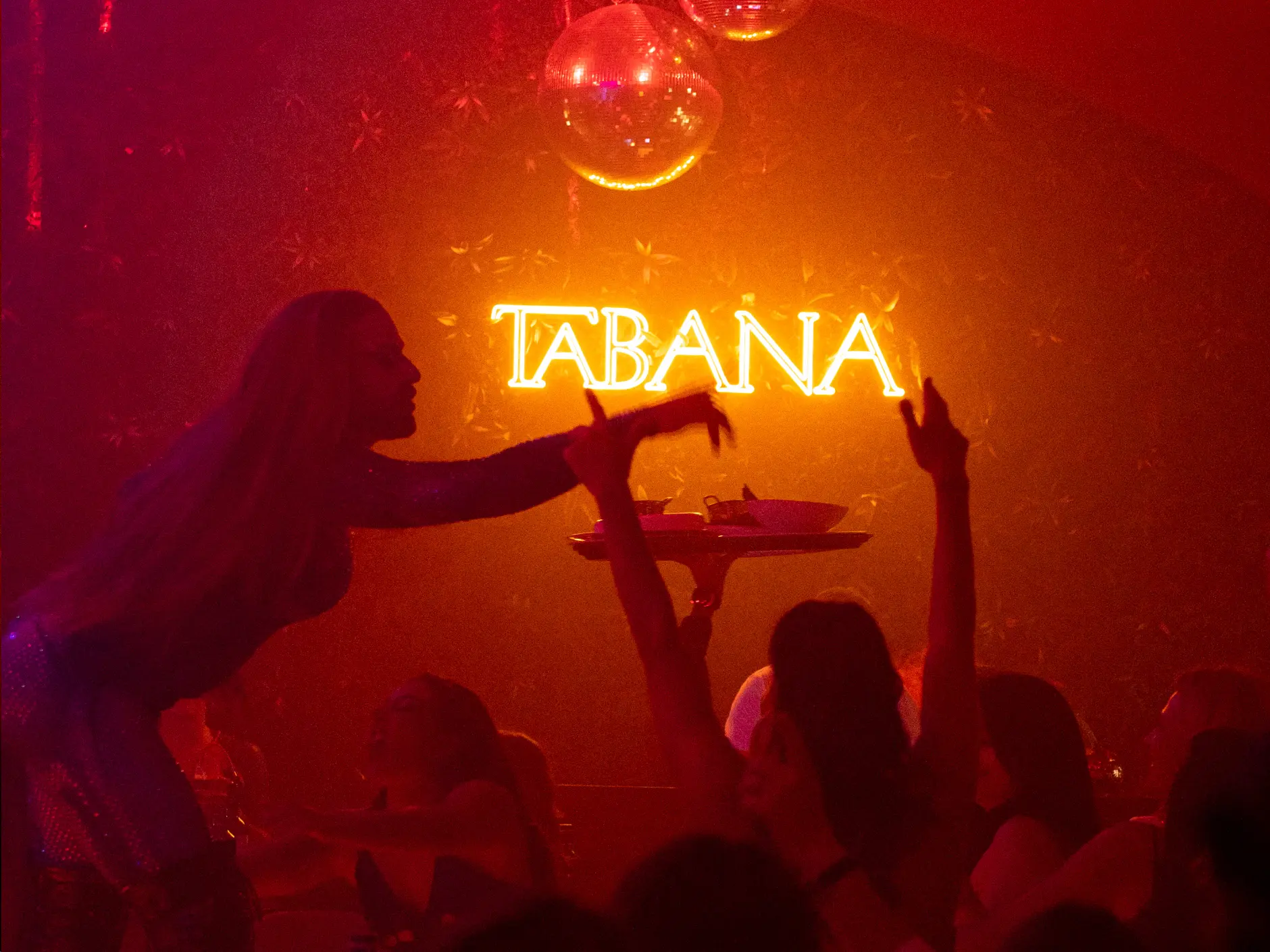 Dancer performing under the neon Tabana sign as guests cheer during a night out at Tabana in Playa de Palma, Mallorca