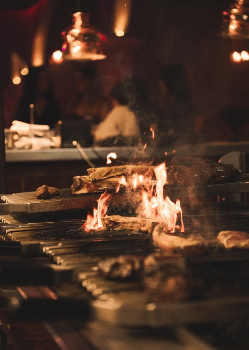 Carne cocinándose sobre una parrilla de leña en Tabana, Playa de Palma
