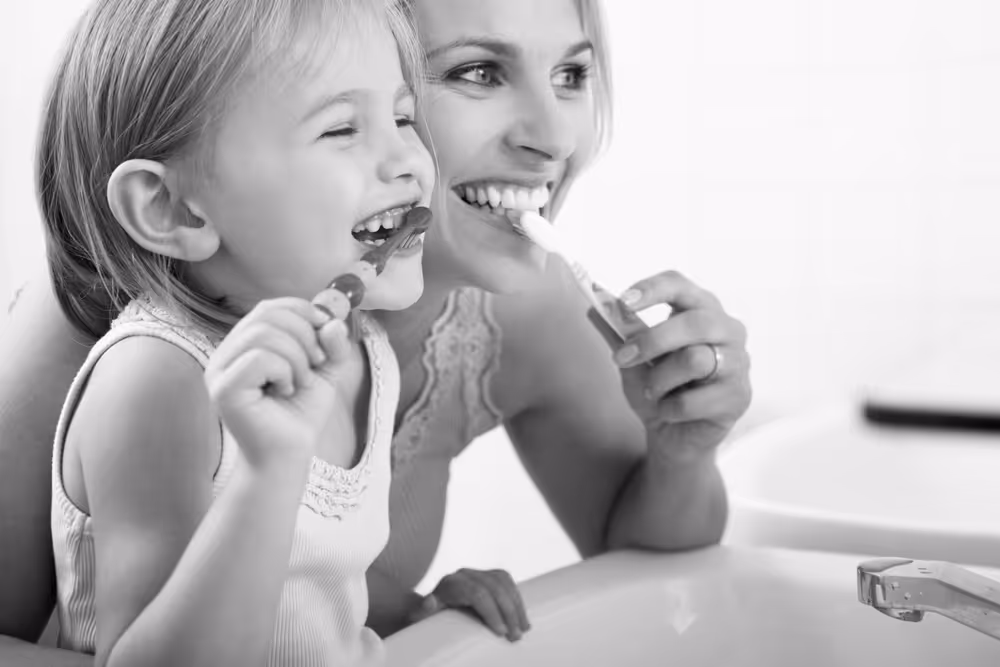 Mother and child brushing their teeth