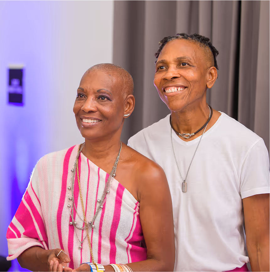 Two smiling guests pose together at an Overtown Performing Arts Center community event