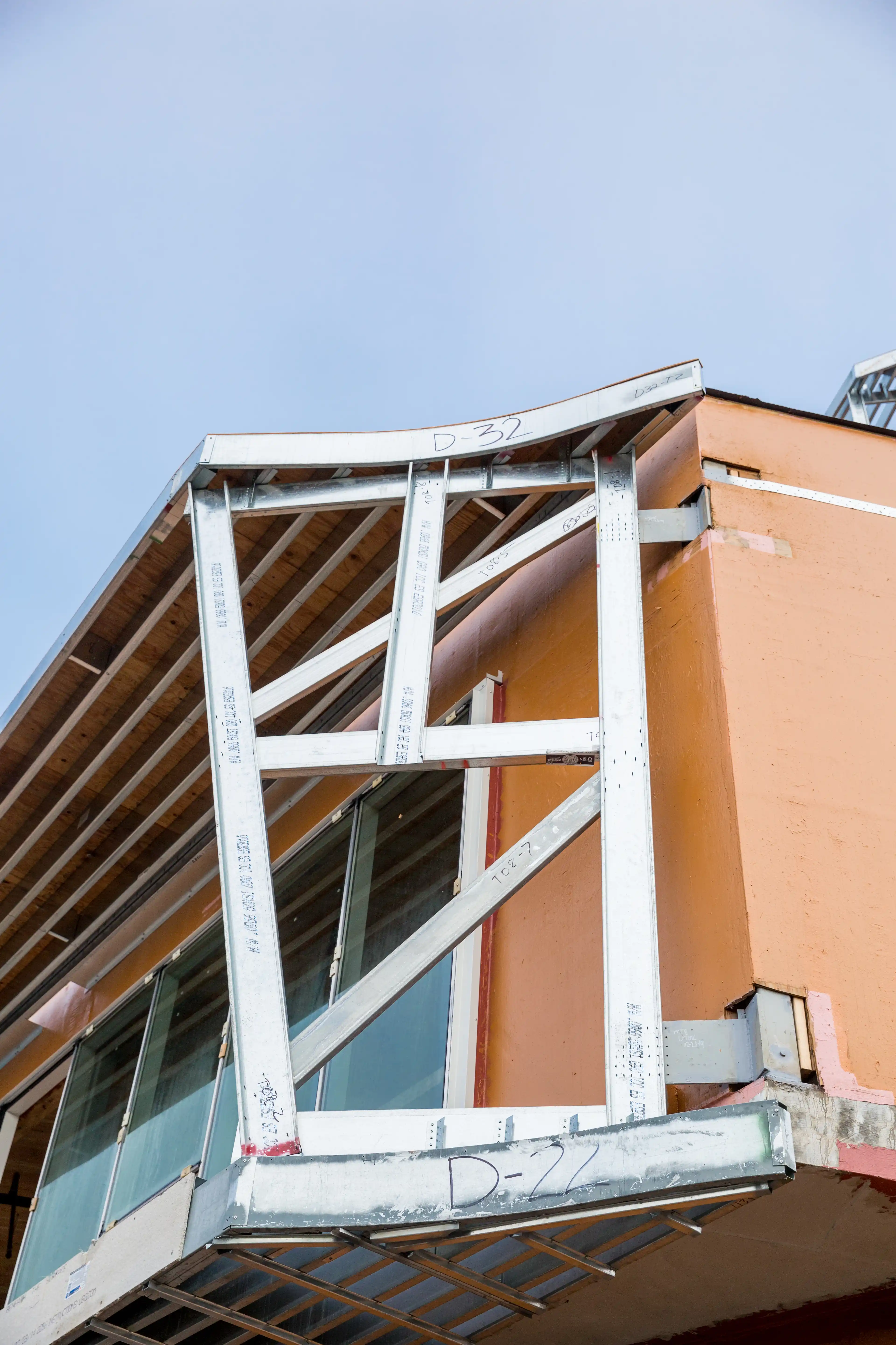 Partially constructed balcony with end truss supporting prefabricated metal deck assembly.