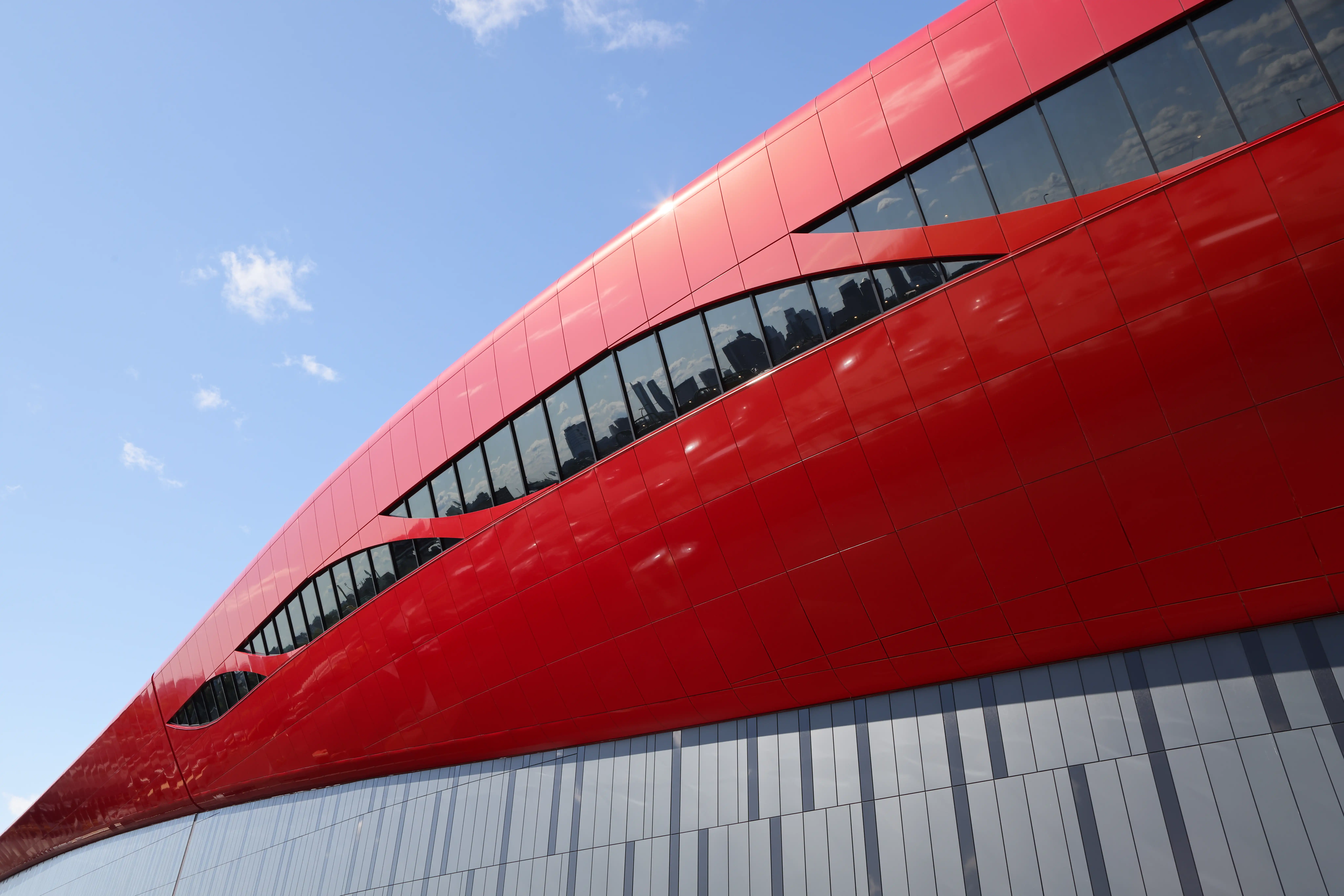 Doubly curved red metal façade at Logan Terminal D in Boston engineered with panelized cold formed steel framing by Radius Track