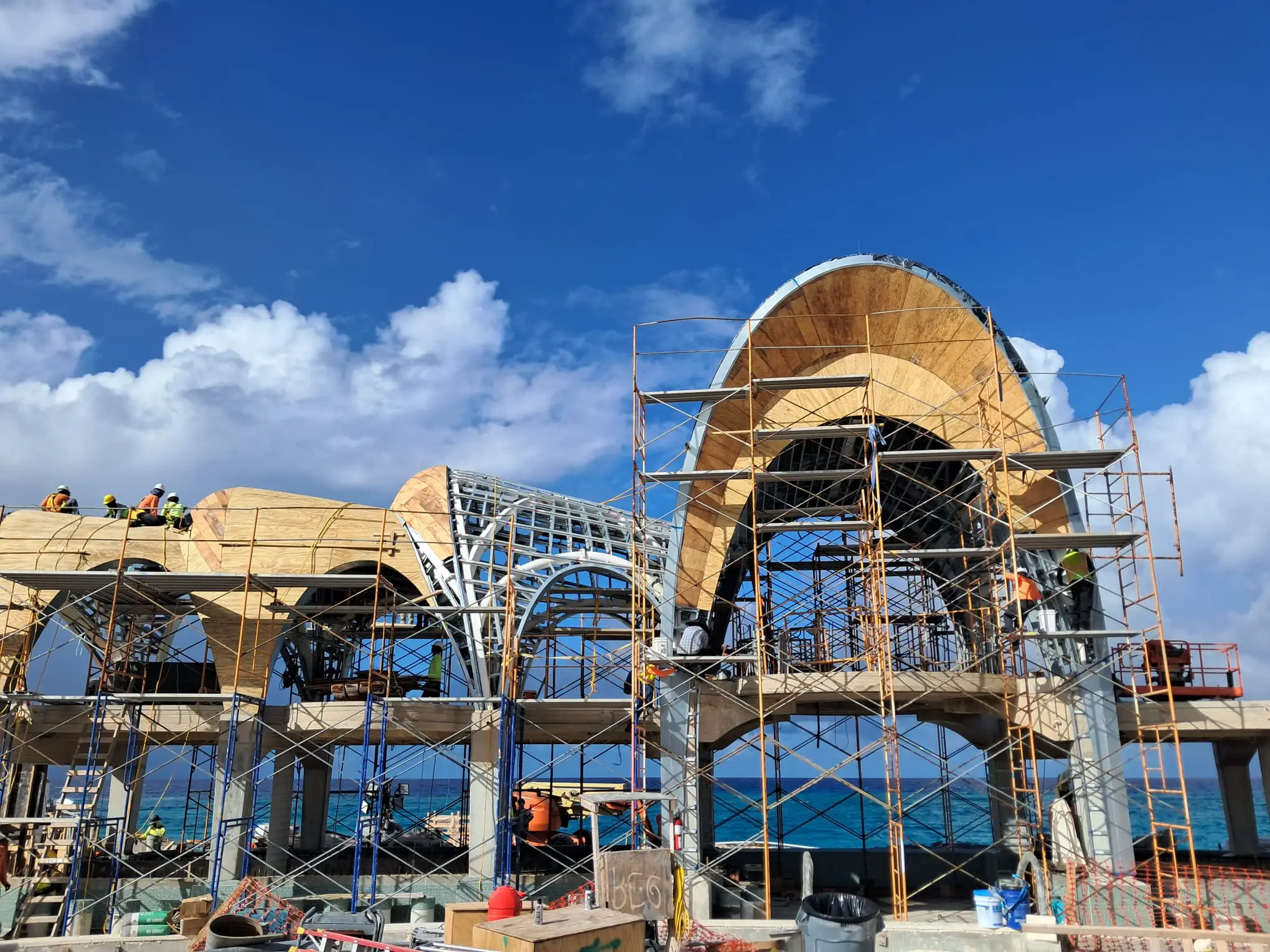 Curved pavilion roof structure during sheathing installation at Paradise Island resort construction site