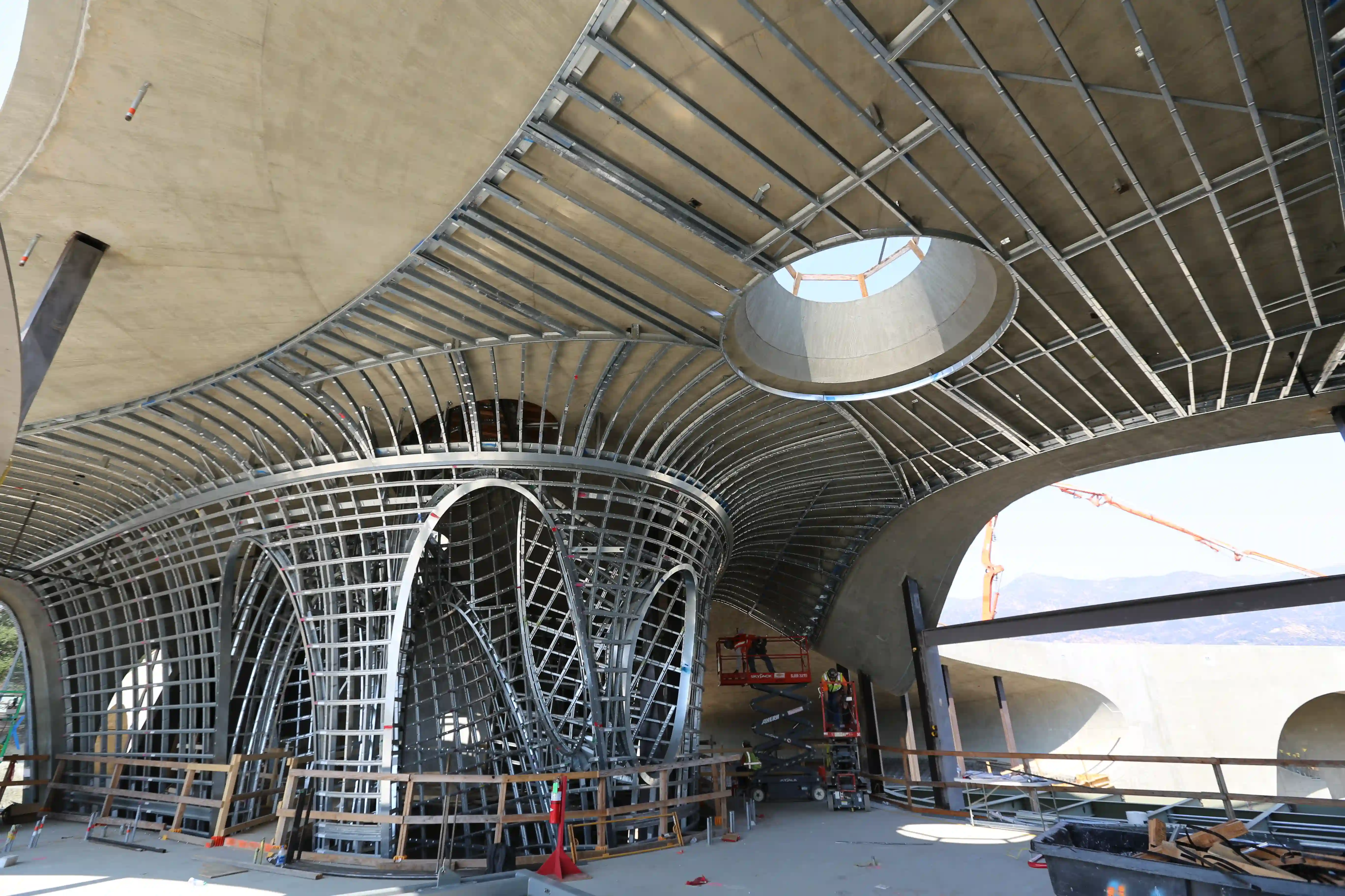 Flowing curved ceiling with circular skylights and soft daylight illustrating precision complex framing at Hill House
