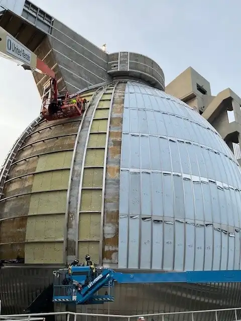Phased installation of curved exterior cladding panels on large spherical industrial digester structure