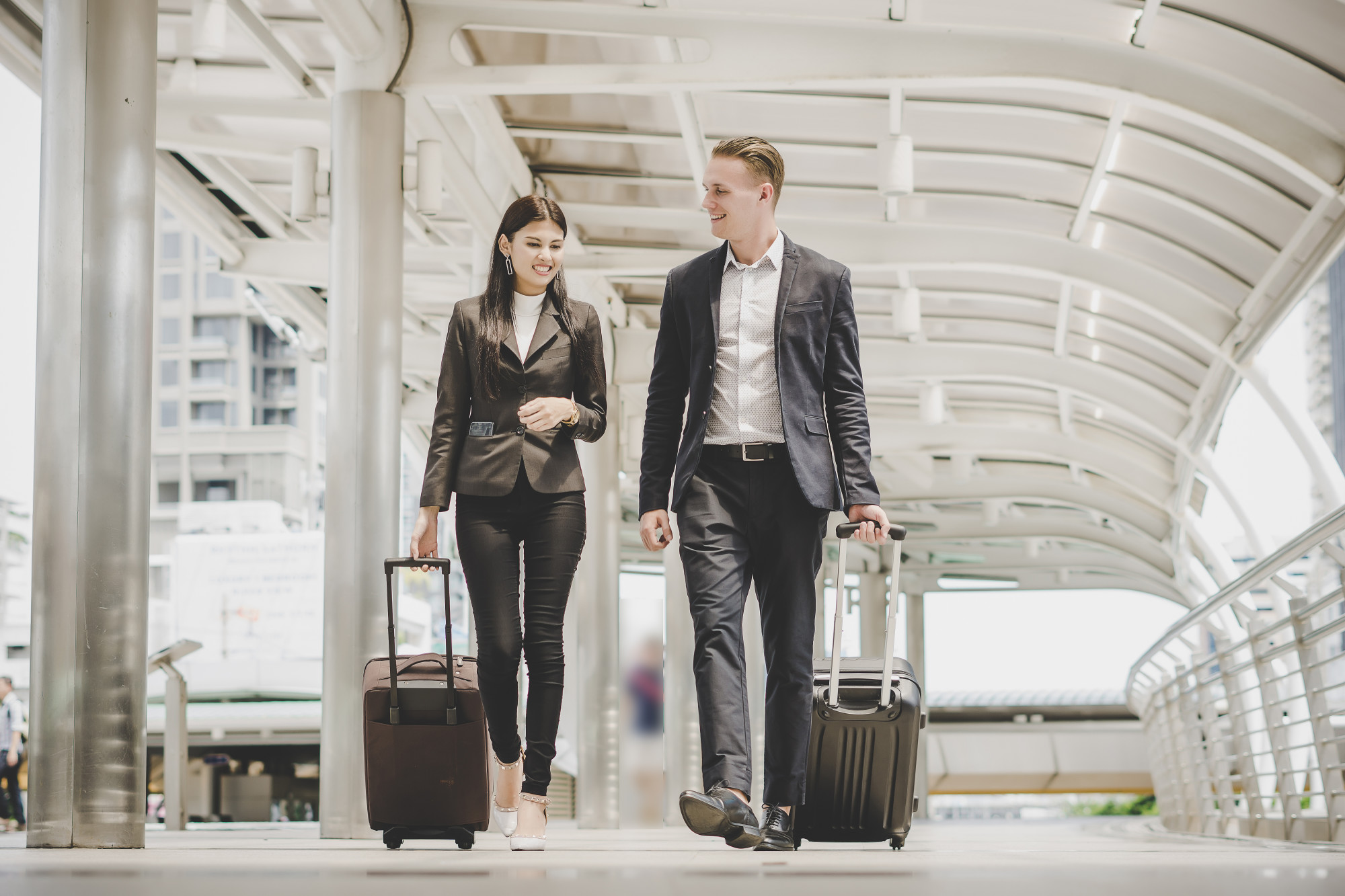 people walking with their bags - How To Save Money On Business Travel