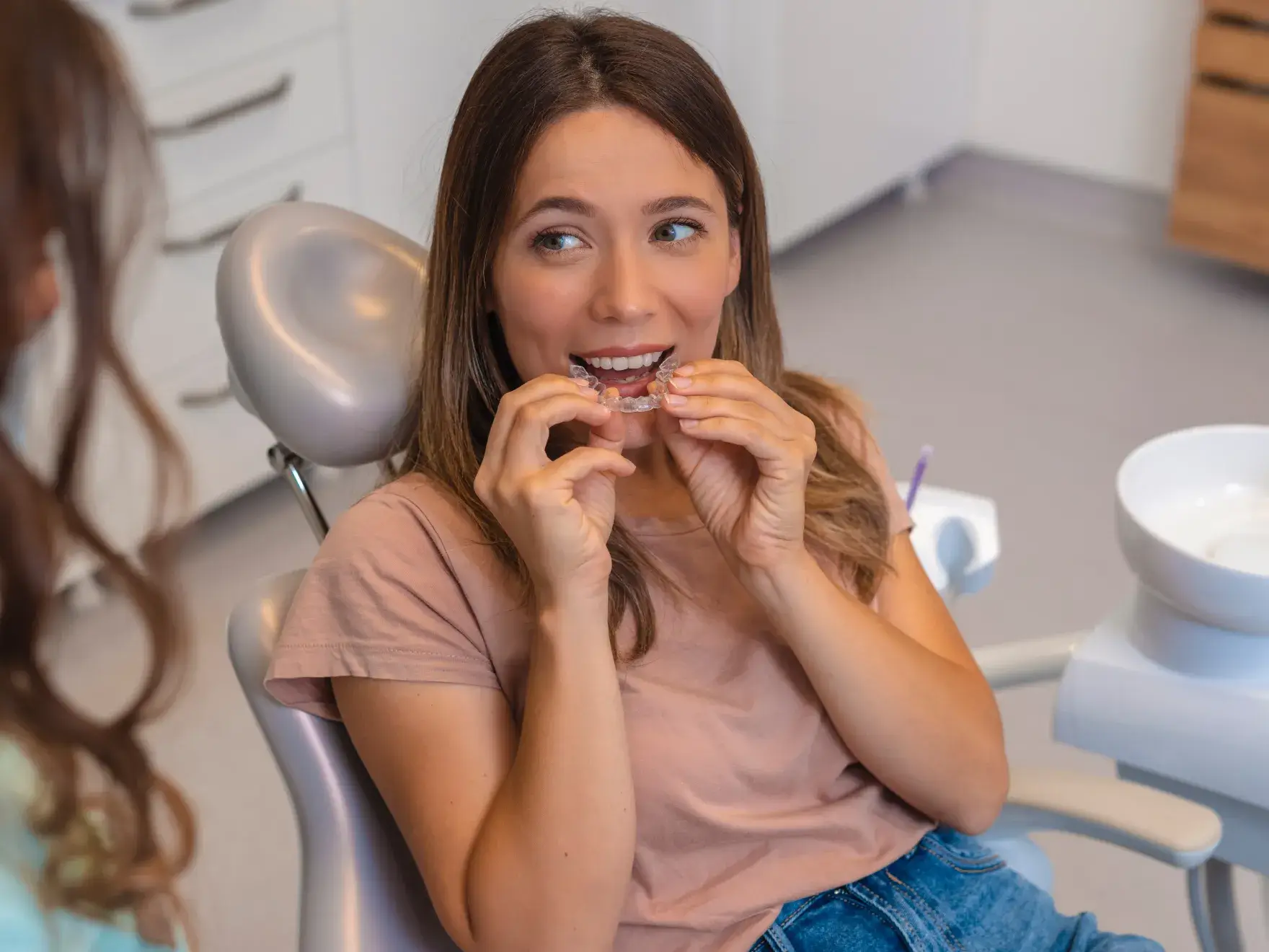 A woman sitting in a chair while brushing her teeth.