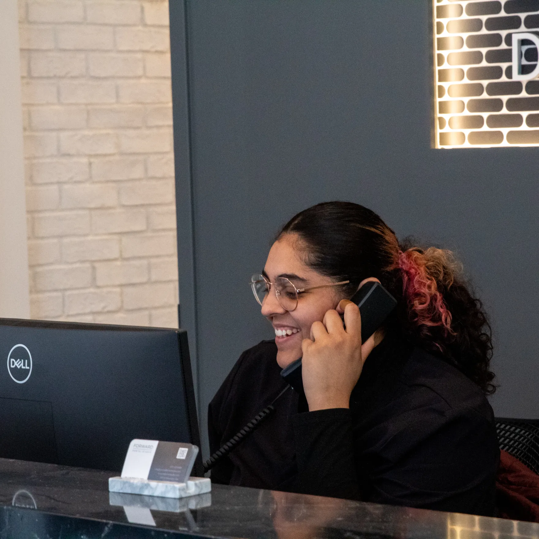 Forward Dental Studio team member talking on the phone