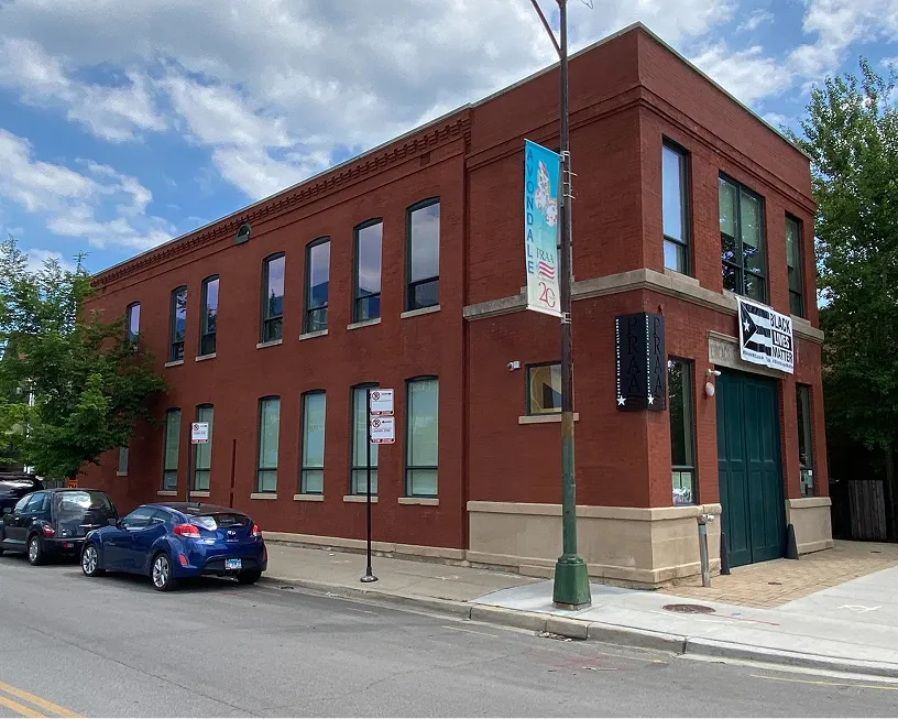 Two-story red brick building on a street corner.