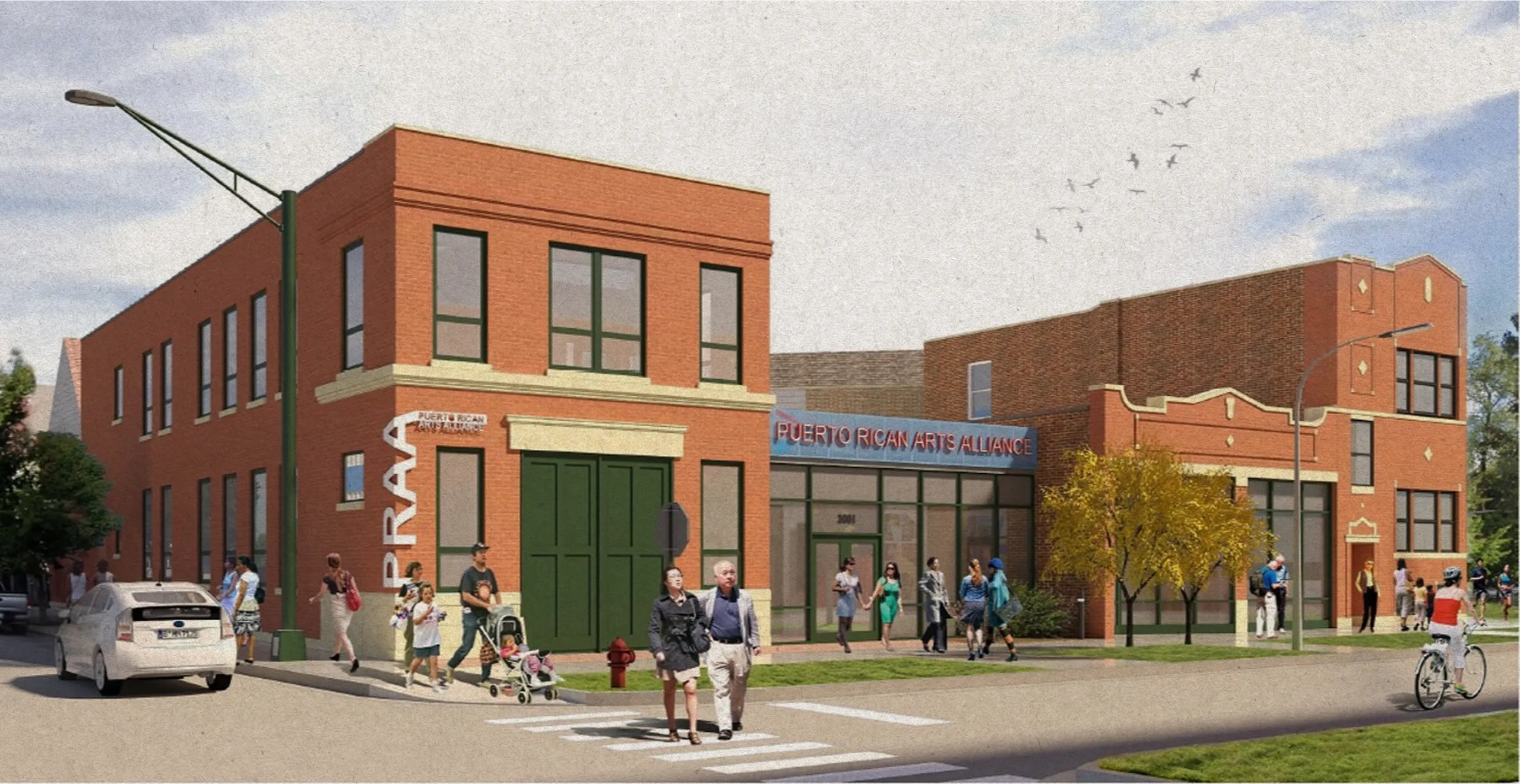 Street view of the Puerto Rican Arts Alliance building with people walking and biking nearby on a sunny day.