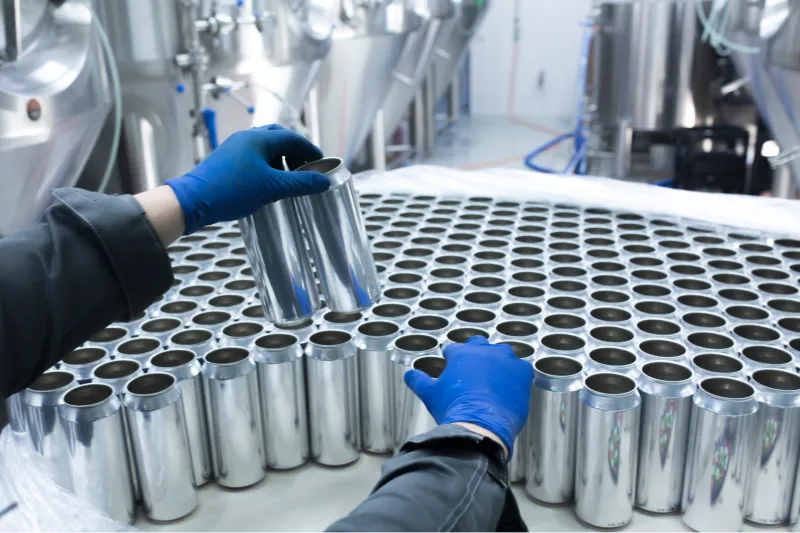 Employee arranging blank aluminum cans. 
