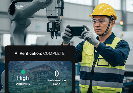 A man in a yellow safety vest is taking a picture of a machine with a smart phone.