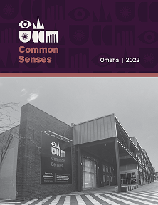 A black and white photo of a modern brick building with large windows and a covered entrance. On the building is a sign with a logo and the words "Common Senses Omaha." Above the photo, on a purple background, are stylized eye and ear icons alongside the logo and the words "Common Senses." In the top right corner, it says "Omaha | 2022."