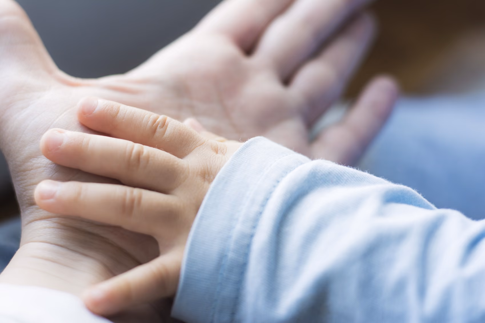 Baby's hand on mother's hand.
