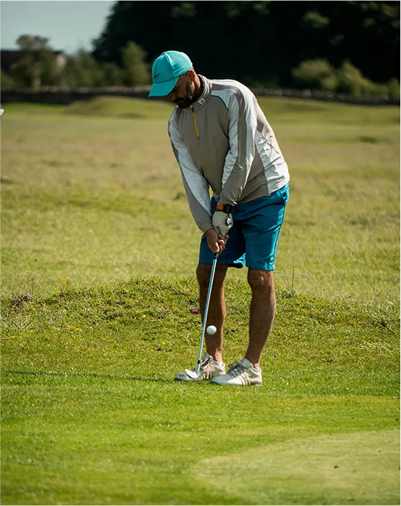 man playing golf on a green field
