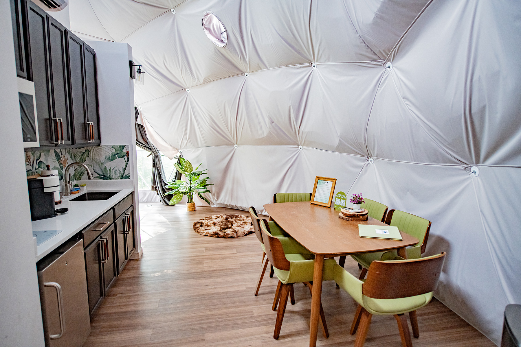 dining area with round wooden table inside the dome at Unique Escapes NY