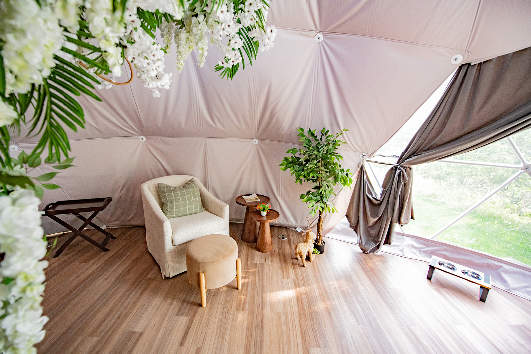 relaxing lounge area with plants and wooden floor inside the dome at Unique Escapes NY
