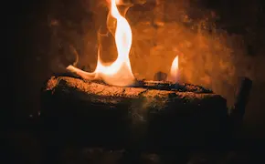 campfire burning at night with glowing flames at Unique Escapes NY