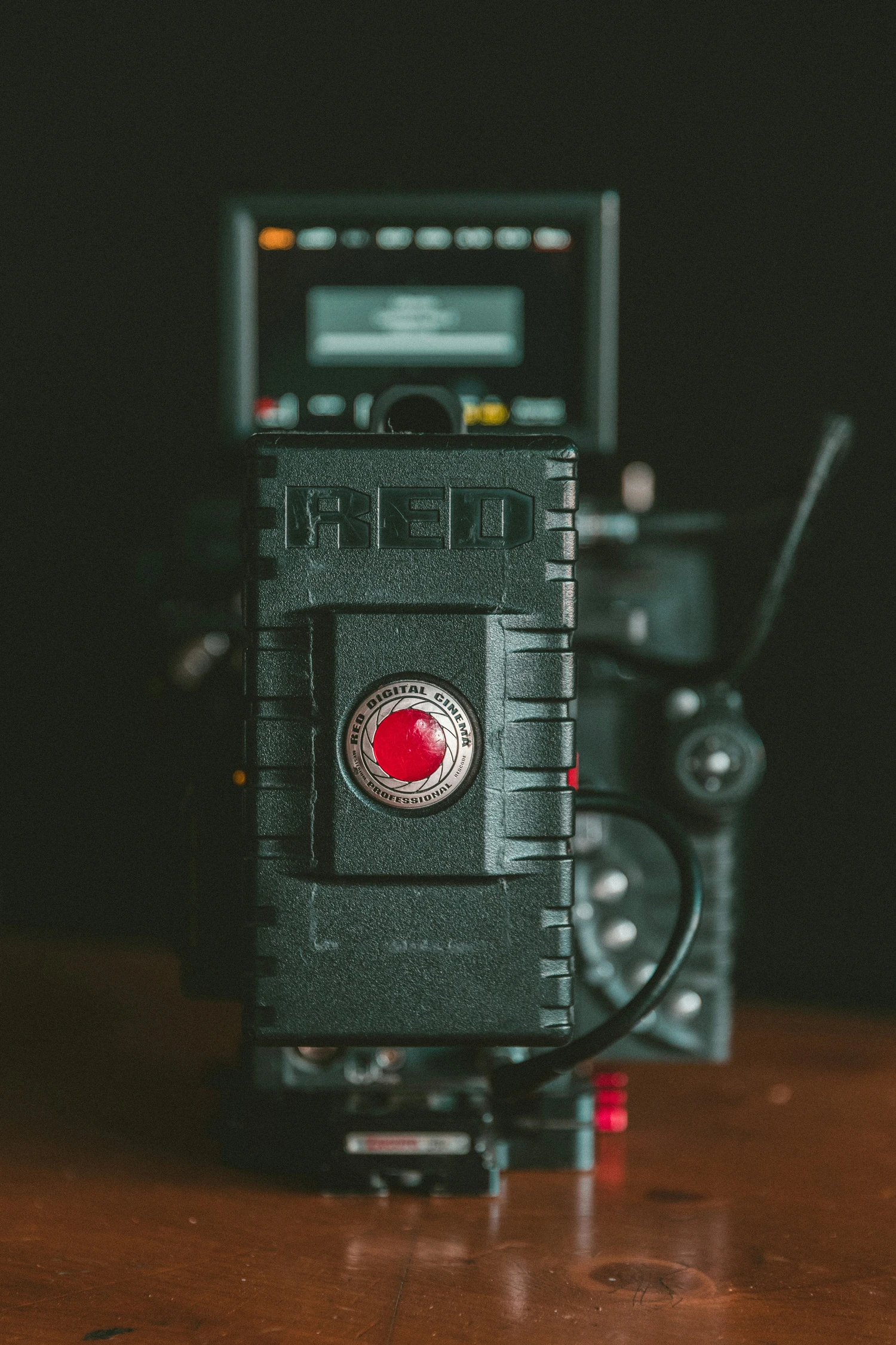 Front view of a RED Digital Cinema professional camera with focused logo and blurred background.