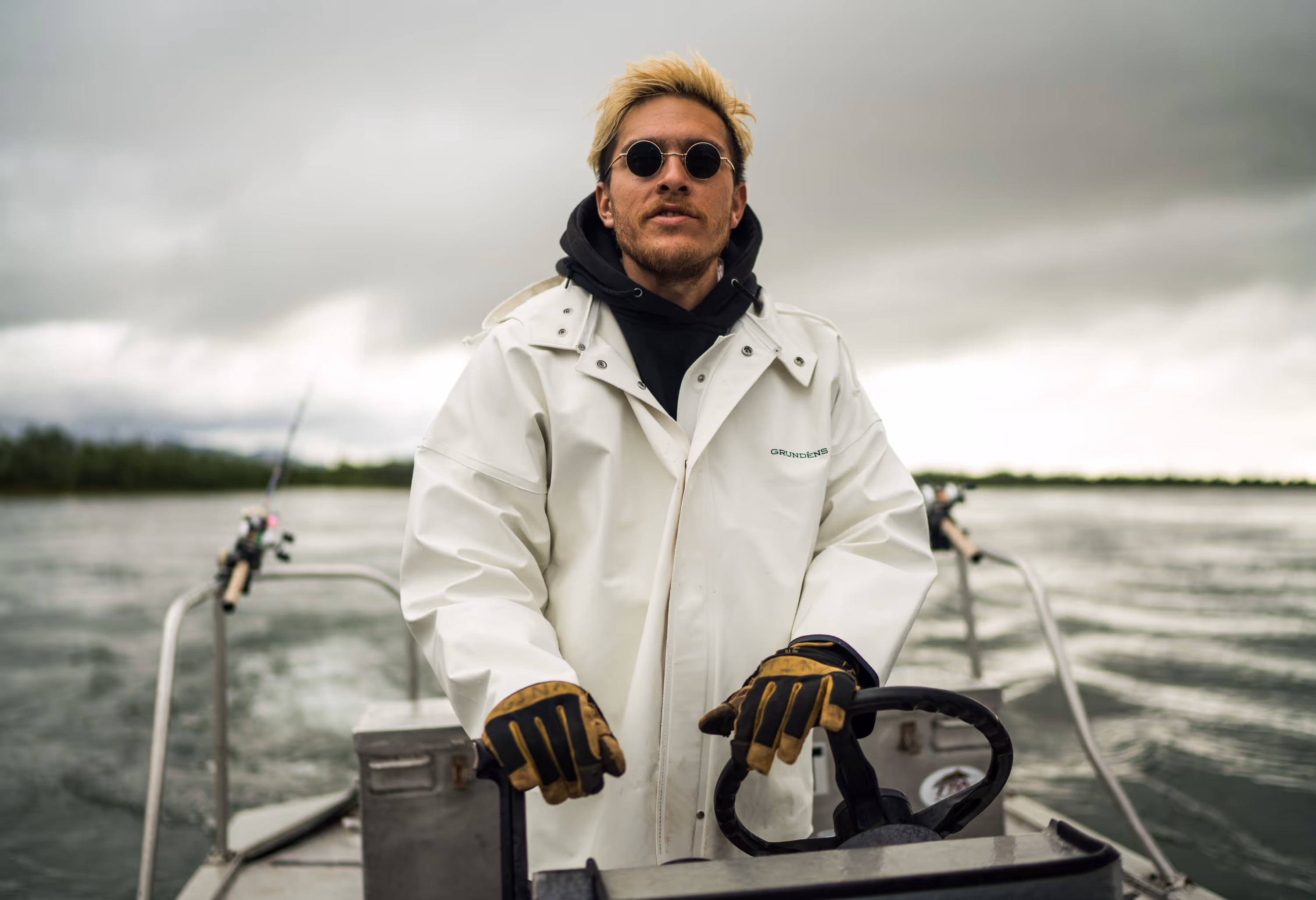 Person in water holding a Camera while a fish splashes on the surface at sunset.