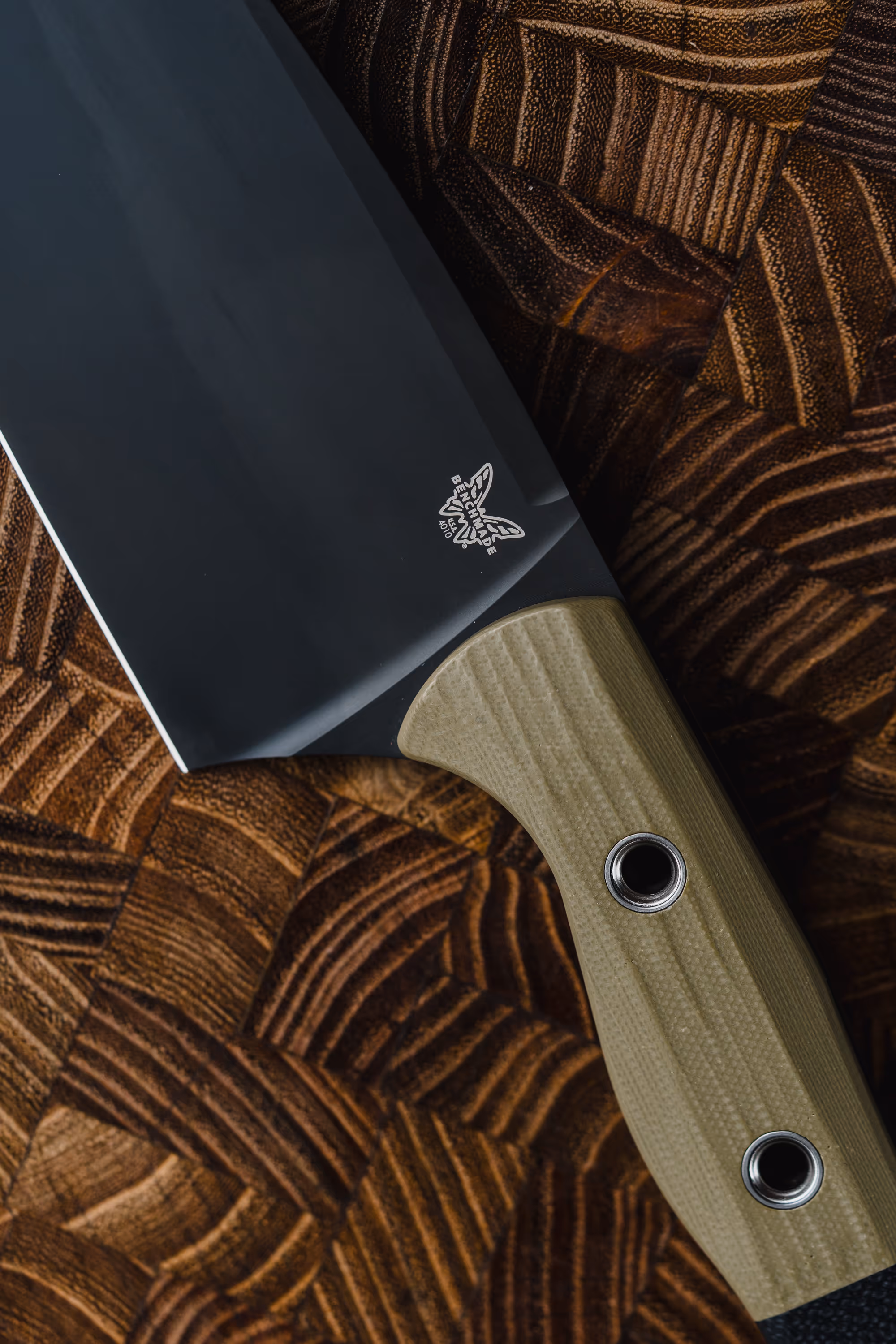 Cooked rack of ribs resting on a cutting board next to a black-handled chef's knife.