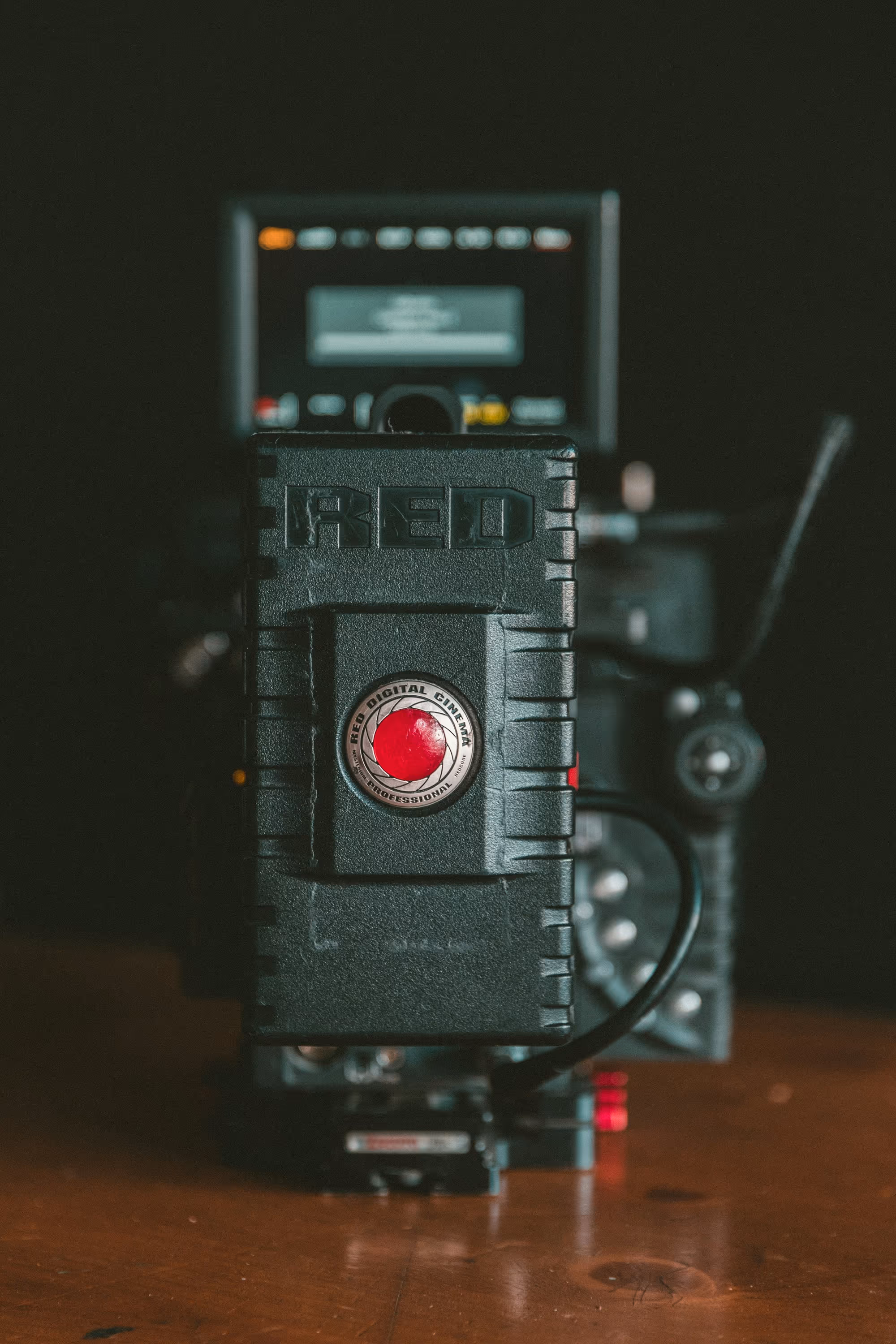 Close-up of a professional RED digital cinema camera battery pack with a red circular logo.