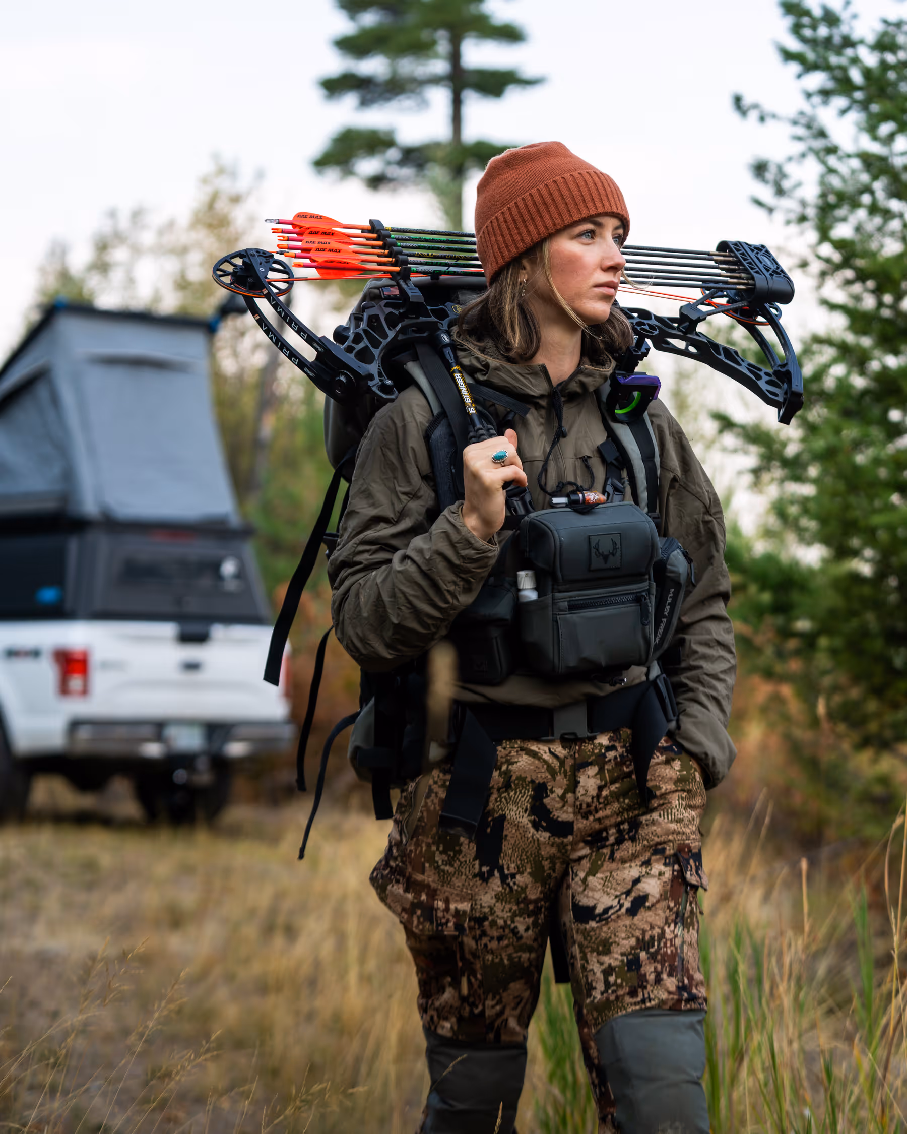 Close-up of a person wearing a textured blue Buff neck gaiter and sunglasses with sunlight in the background.