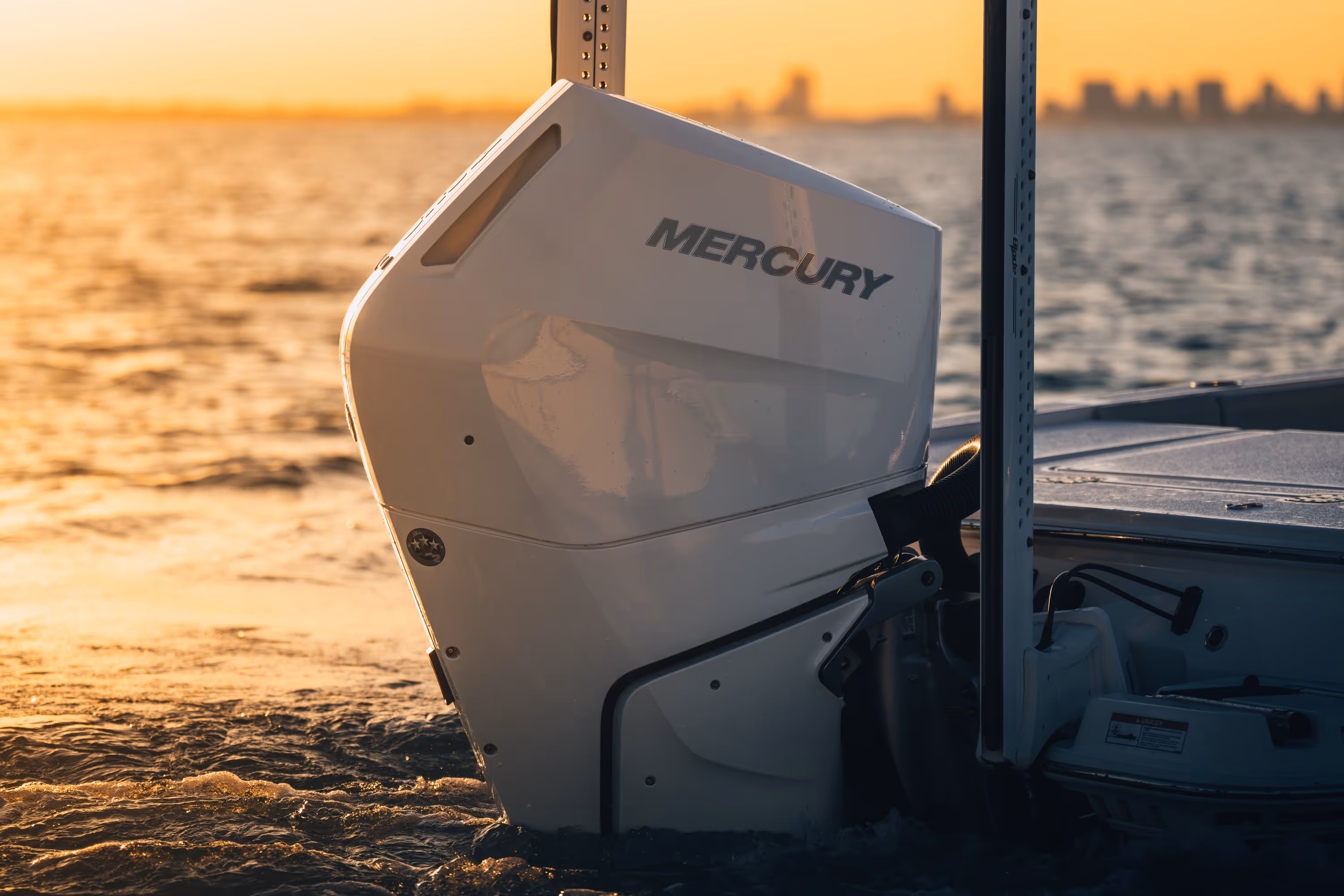 Two people wearing camouflage jackets and waders standing back-to-back in shallow water, one holding a fishing rod and the other a camouflaged rifle.