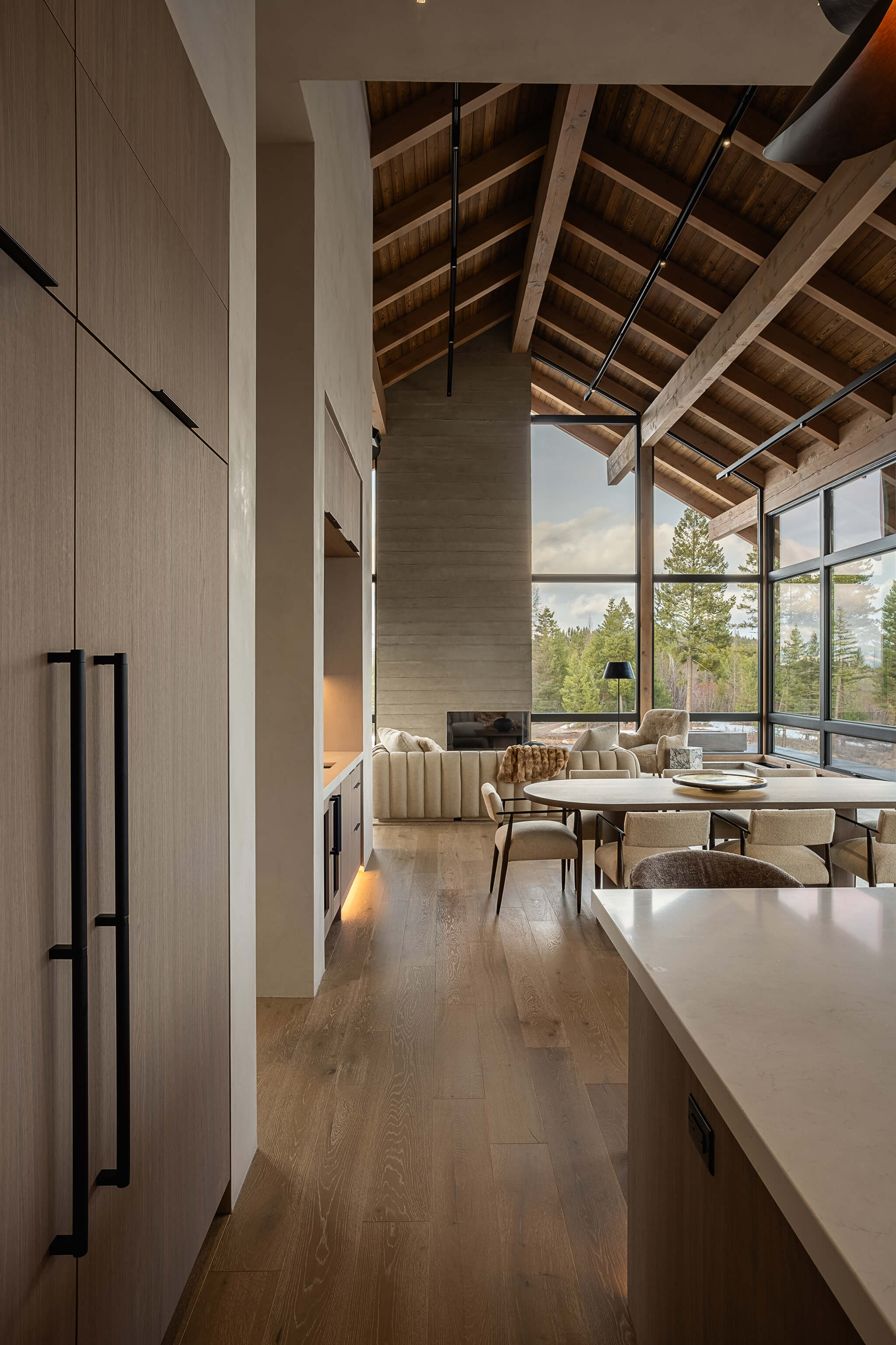 Modern kitchen with a stainless steel gas stove, black cabinetry, a marble countertop, and wooden ceiling and floor.