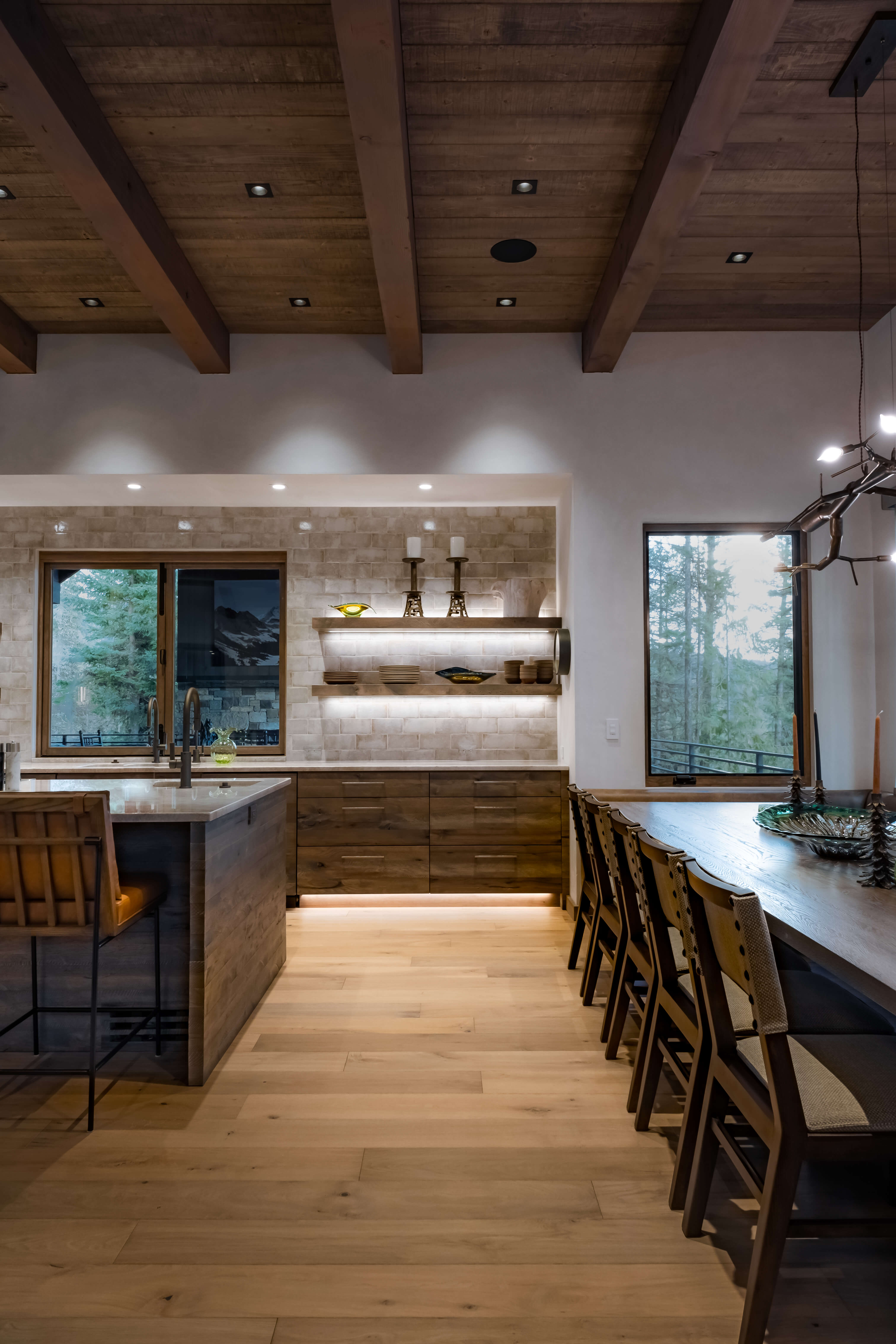 Modern kitchen with a stainless steel gas stove, black cabinetry, a marble countertop, and wooden ceiling and floor.