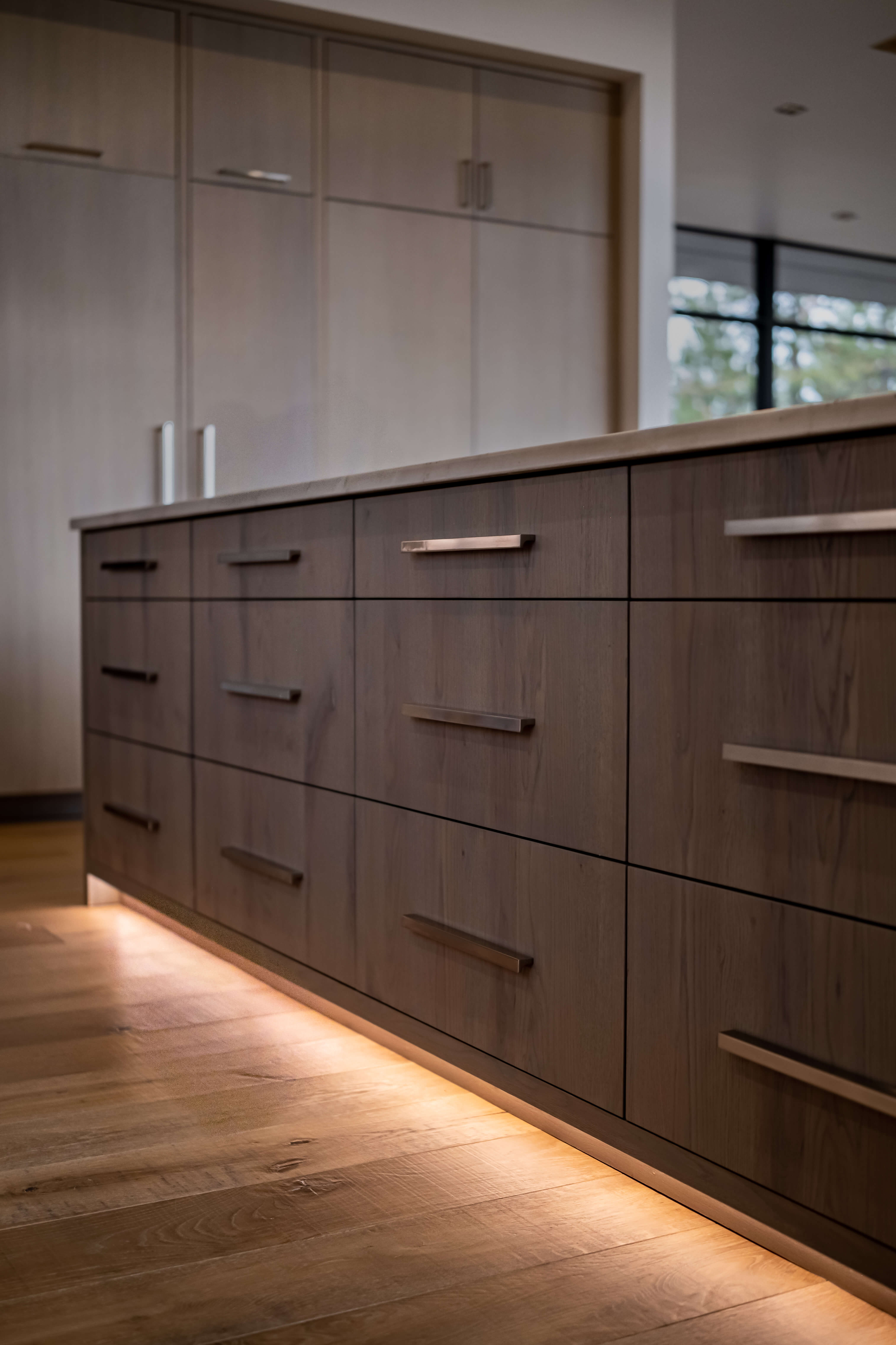 Modern kitchen sink with a stainless steel faucet, gray marble countertop and backsplash, and a stack of white plates.
